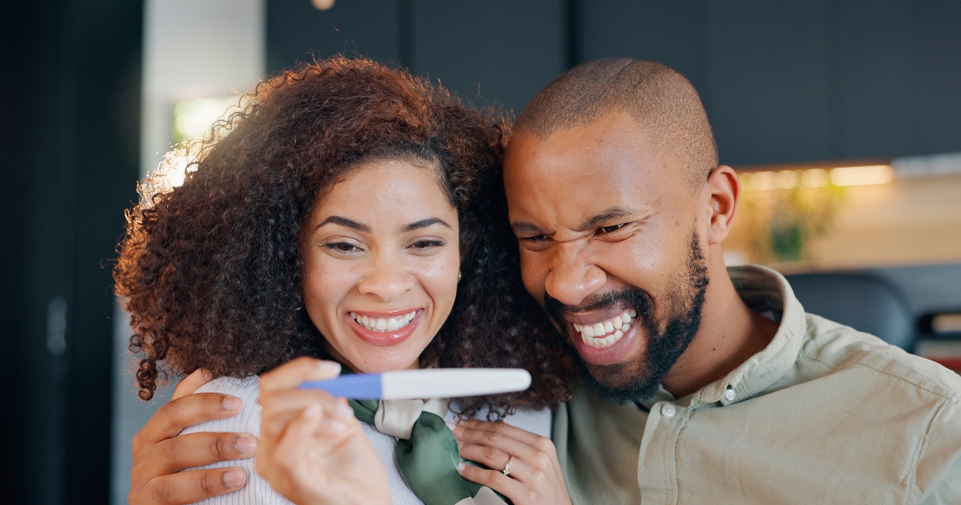 Happy couple, excited and pregnancy test with results, good news and planning for baby as married people. Woman, man and joy for future family in home, together and cheerful in celebration as parents
