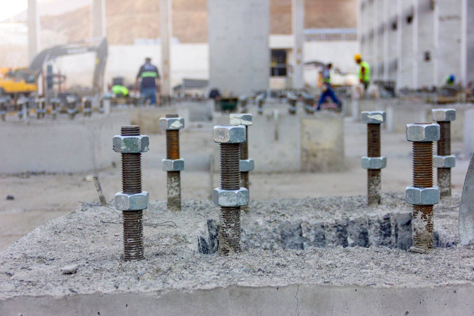 The anchor bolts in the concrete foundation of the new industrial plant. These anchors for structural steel construction.