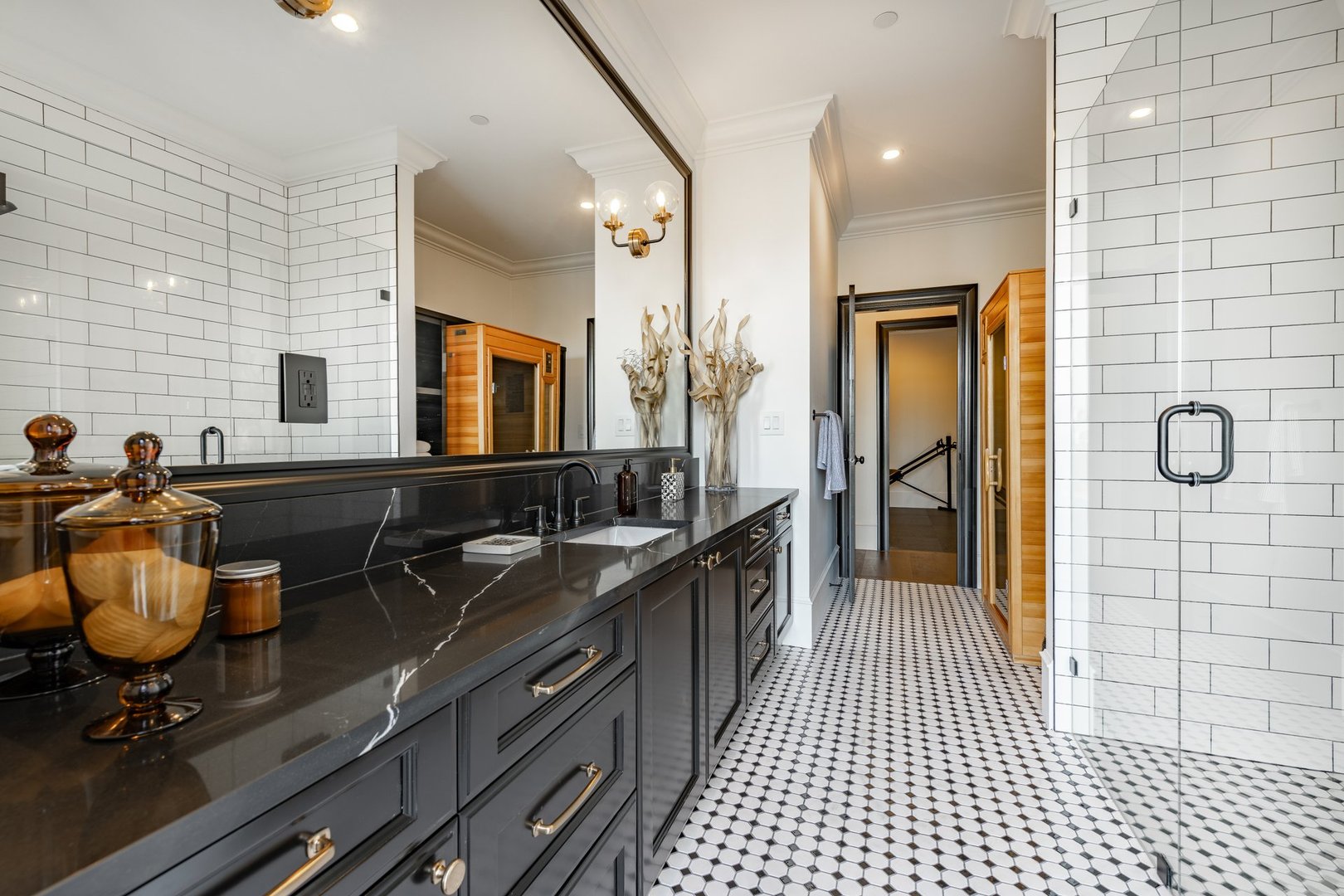 Very large bathroom with luxury decor glass wall shower free standing bathtub double sinks subway tile sauna black cabinets tiled walls built in shelving