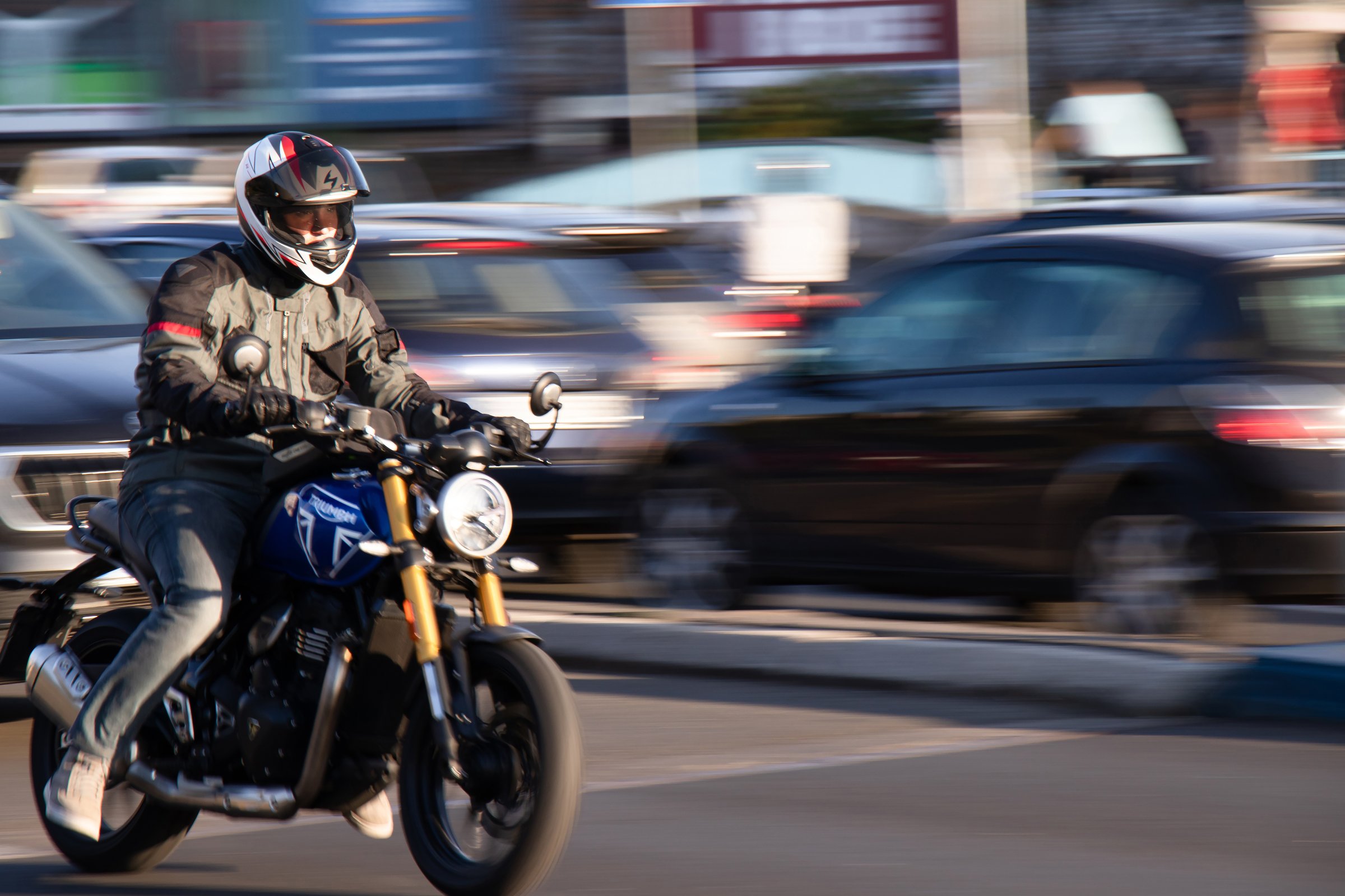 Belgrade, Serbia - October 10, 2024: Young motorcyclist riding a motorbike on busy city street on a sunny day