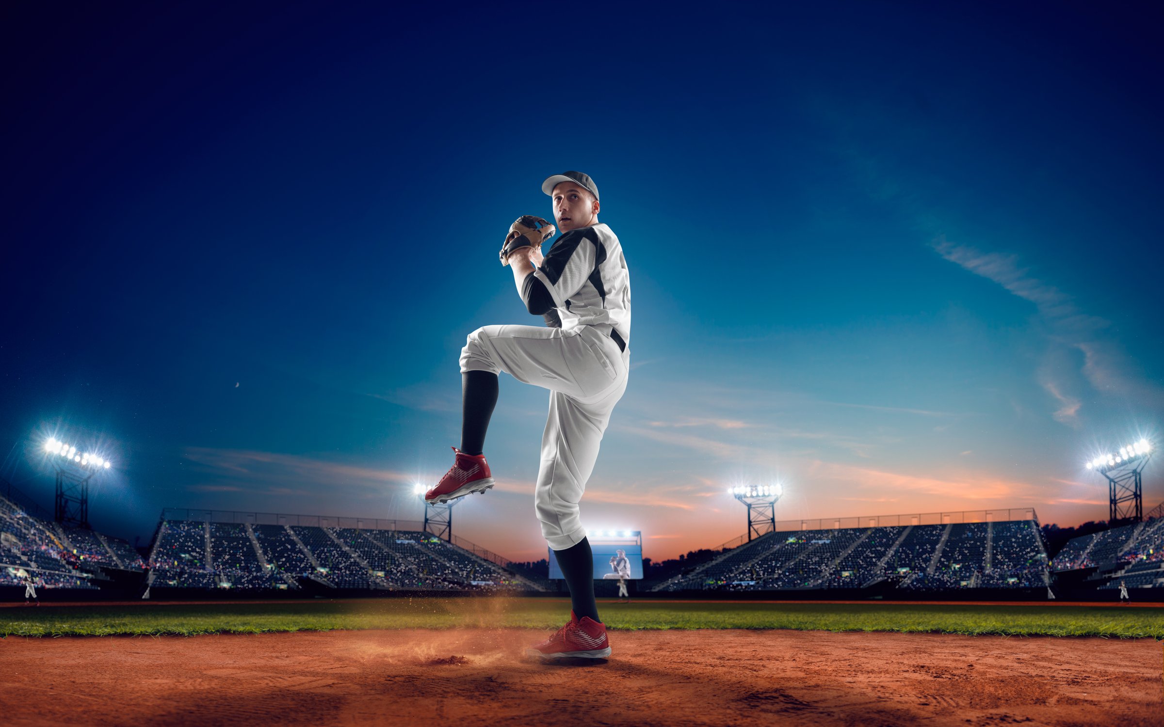 Baseball player at professional baseball stadium in evening during a game.