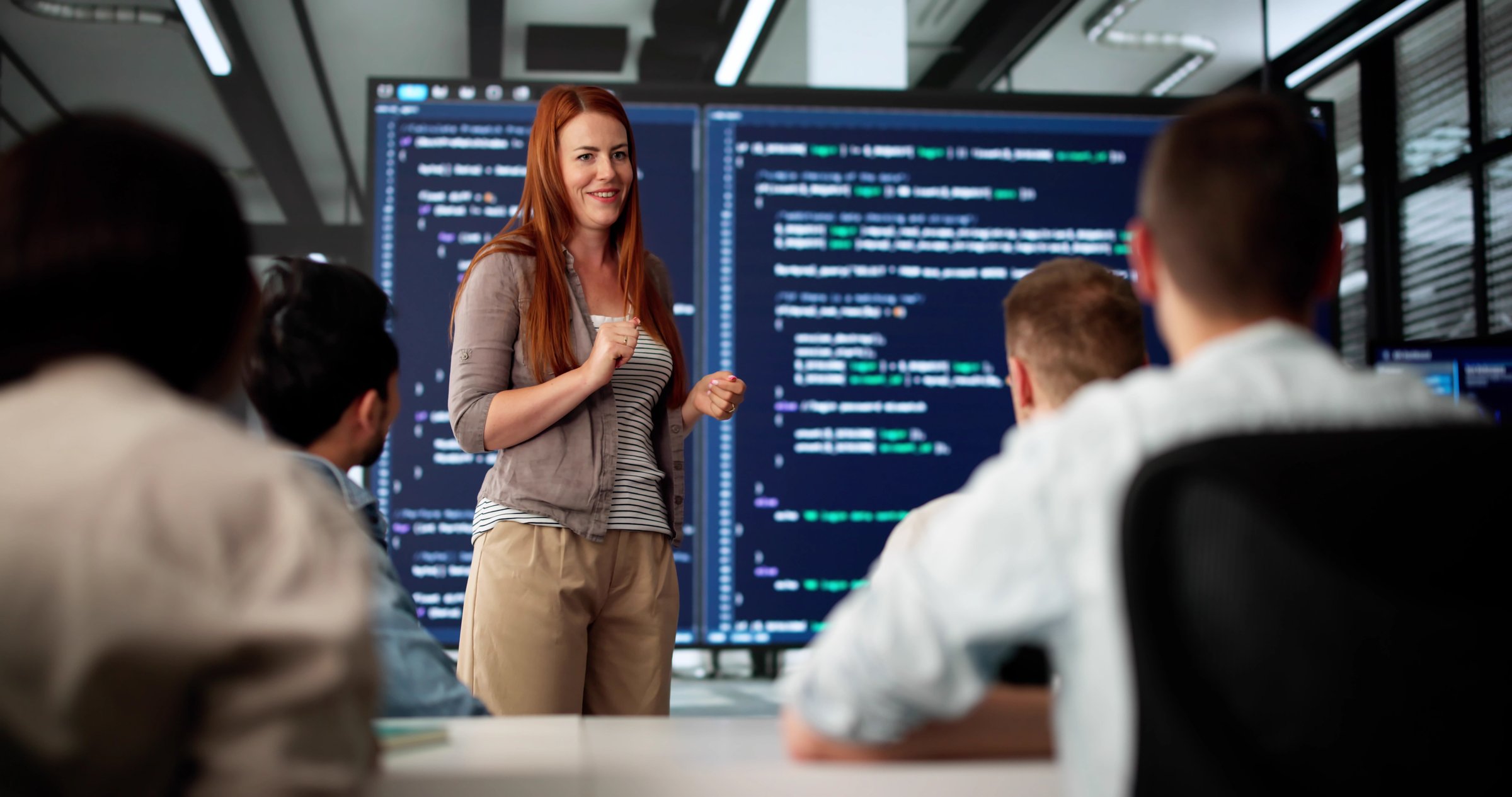Executive Coder Gives Presentation To Diverse Team In Boardroom