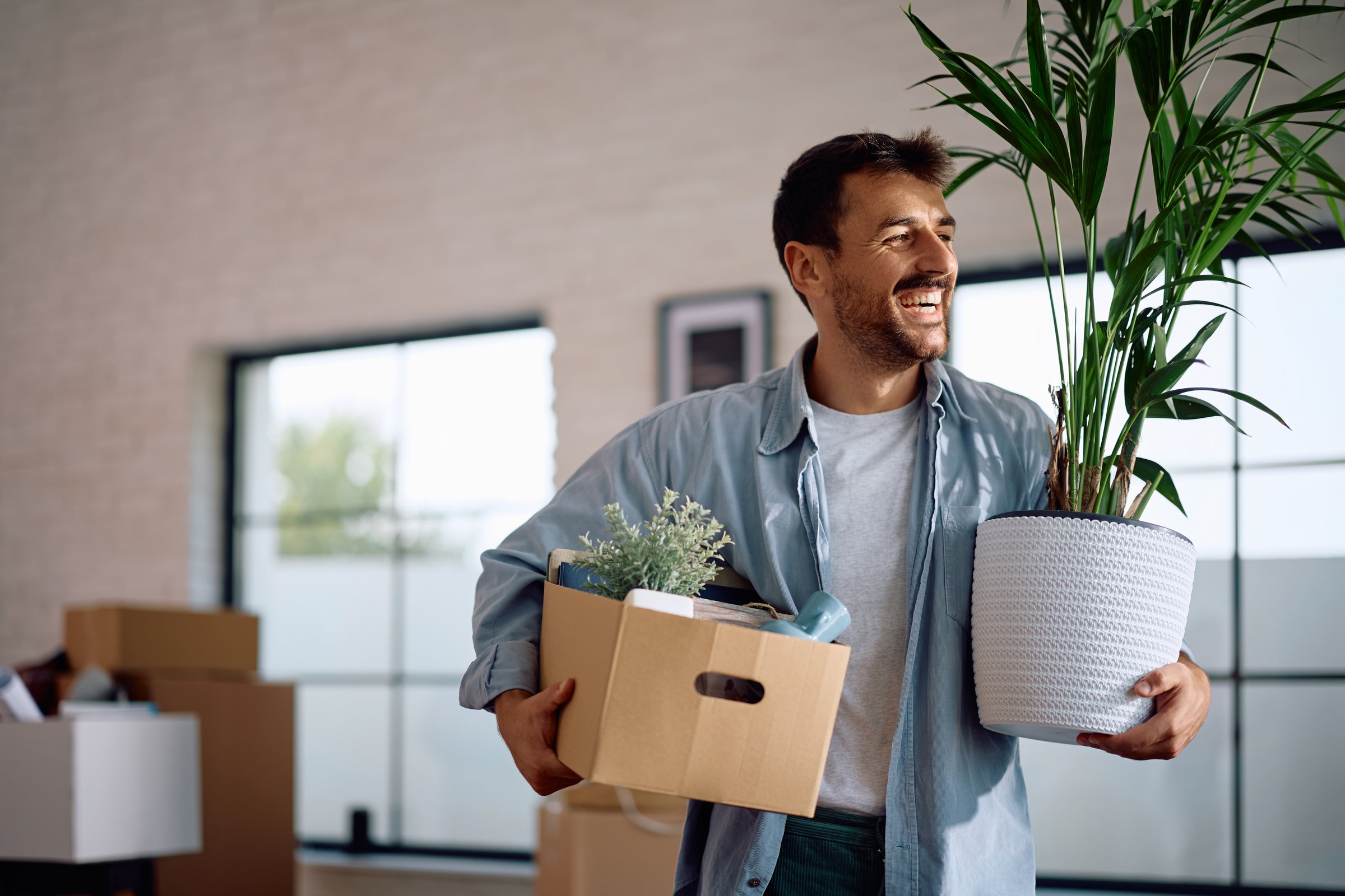 Cheerful man moving into new home. Copy space.
