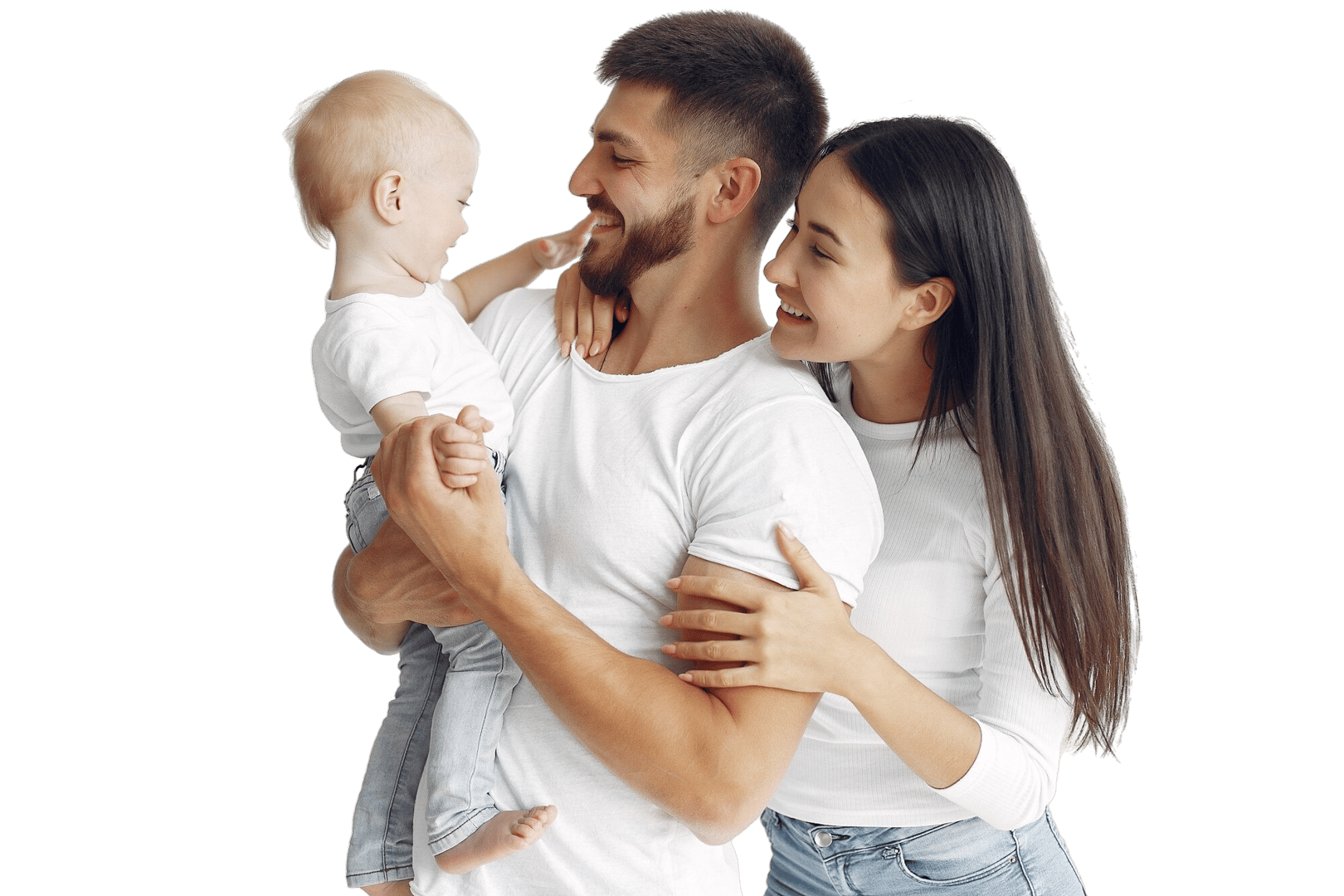 A smiling couple holding a baby, all wearing white shirts against a neutral background.