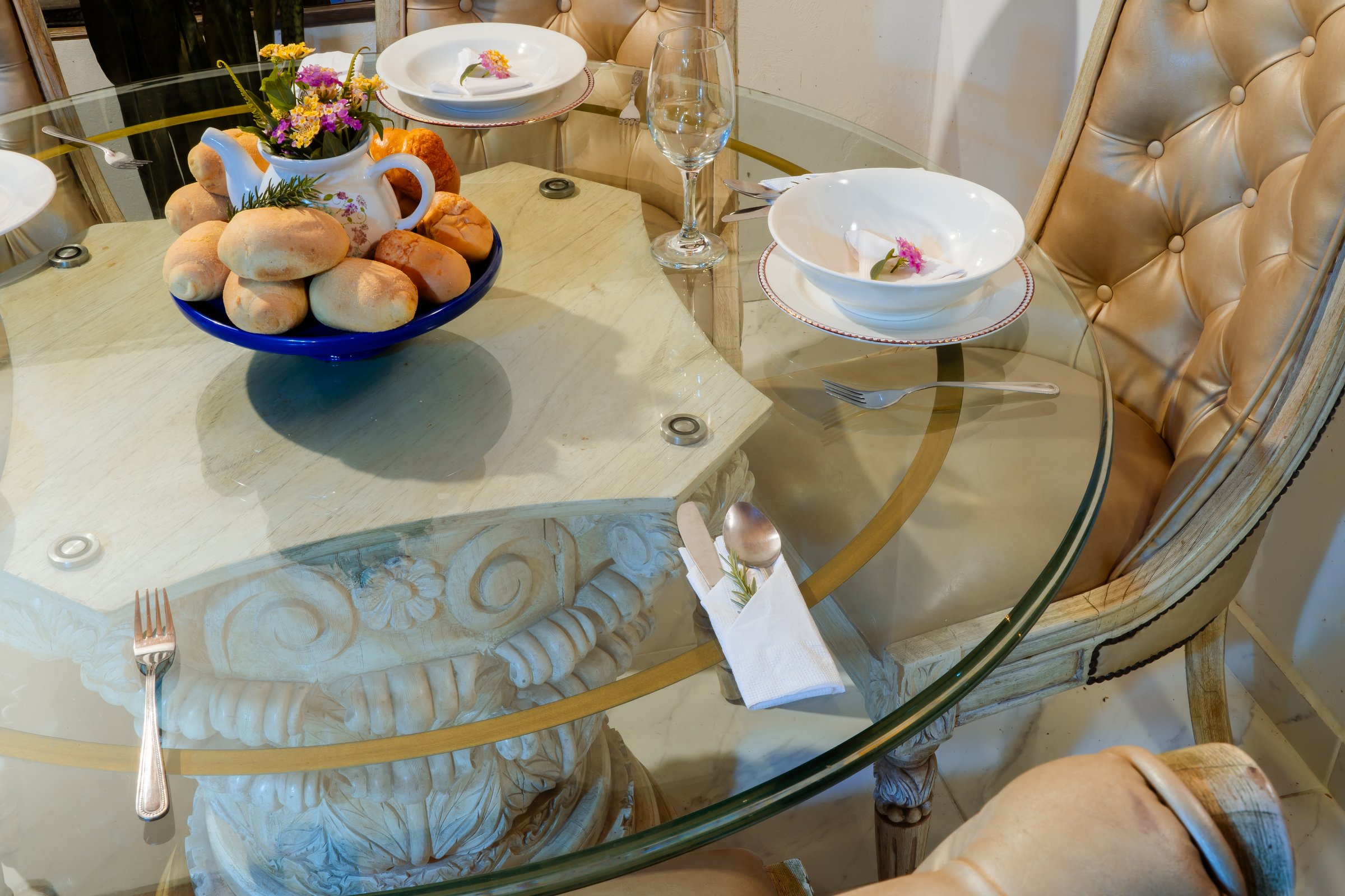 Round glass dining table with floral bowls