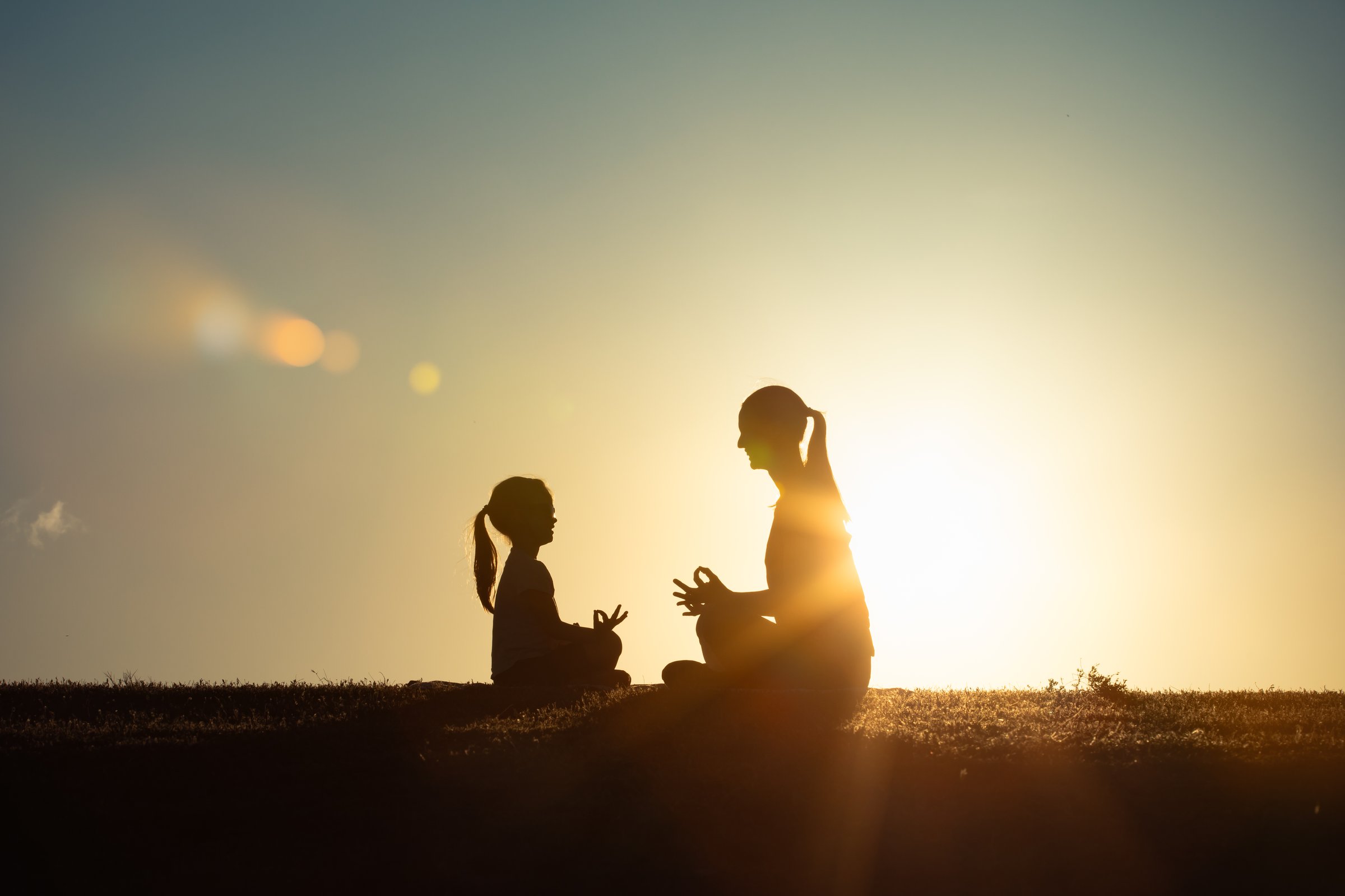 Mother and daughter meditating.
