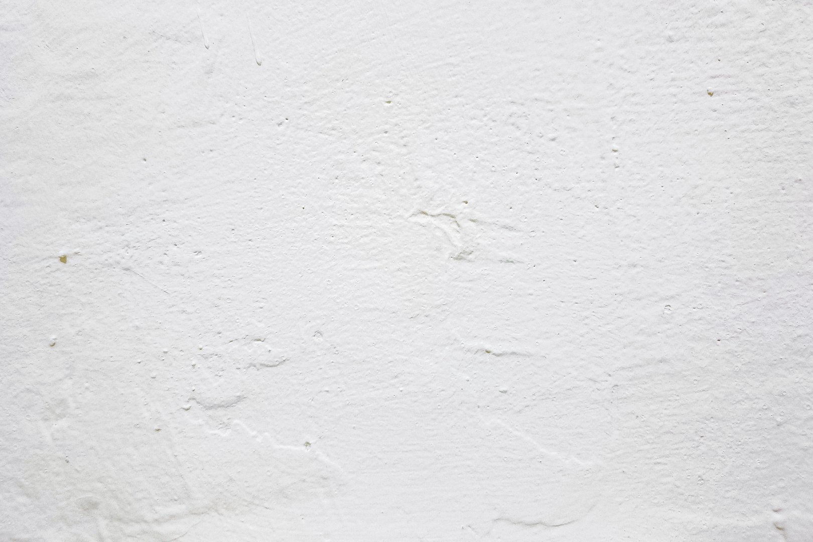 A close-up shot of a plain white concrete wall texture.