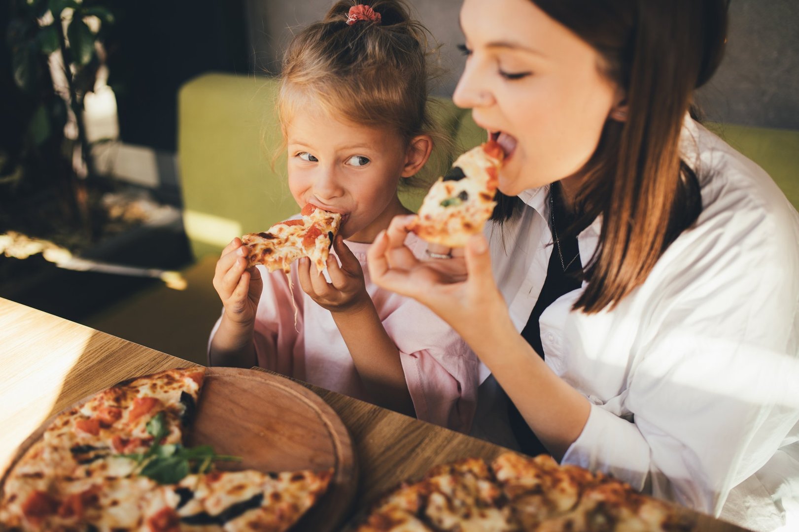 Happy mother and daughter eat pizza in a cafe and having fun - sugarfree.space education about sugar impact