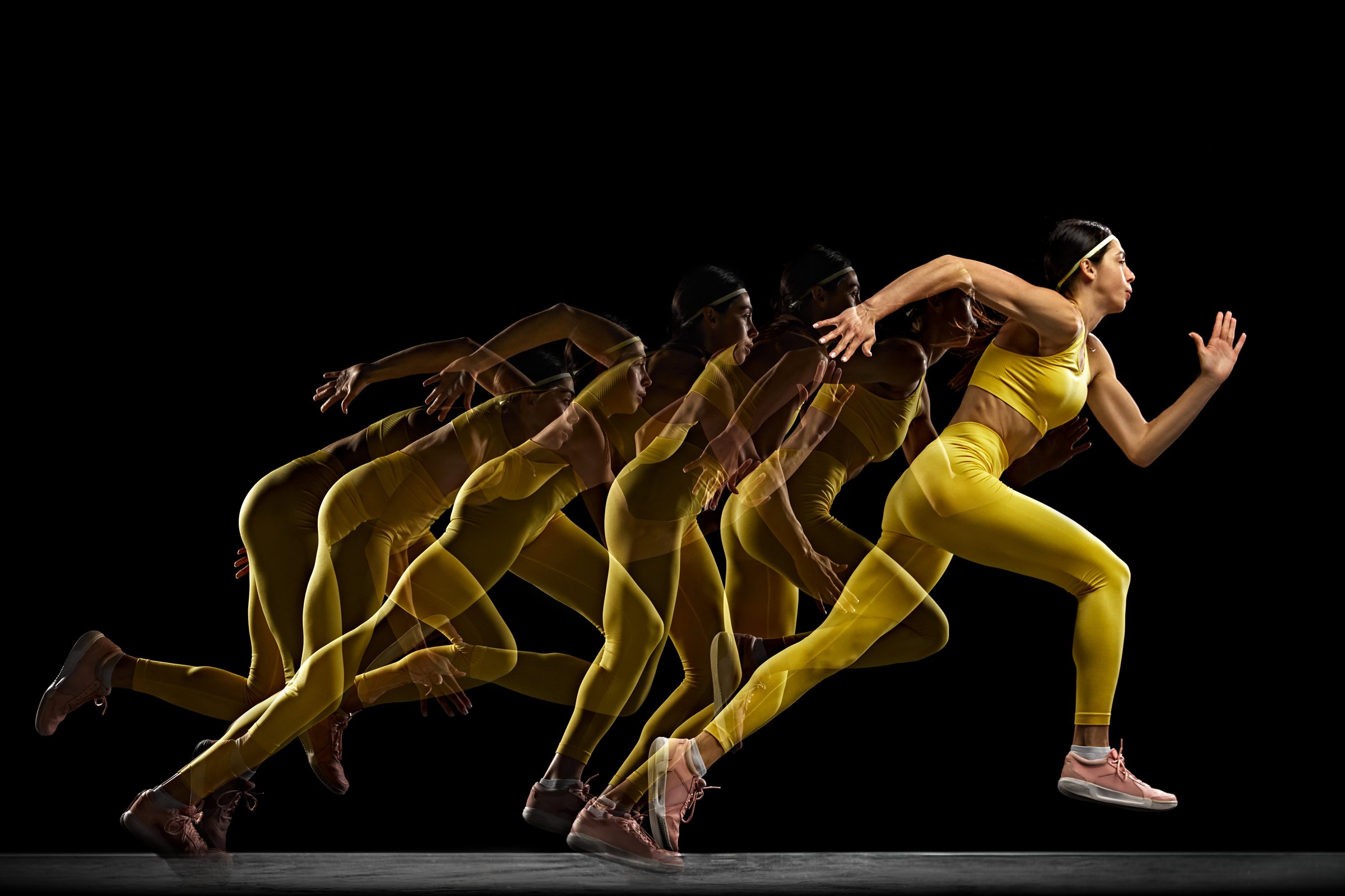 Dynamic image of sportive woman, athlete in motion, showing strength and agility, running against black background with stroboscope effect. Concept of sport, active and healthy lifestyle, endurance
