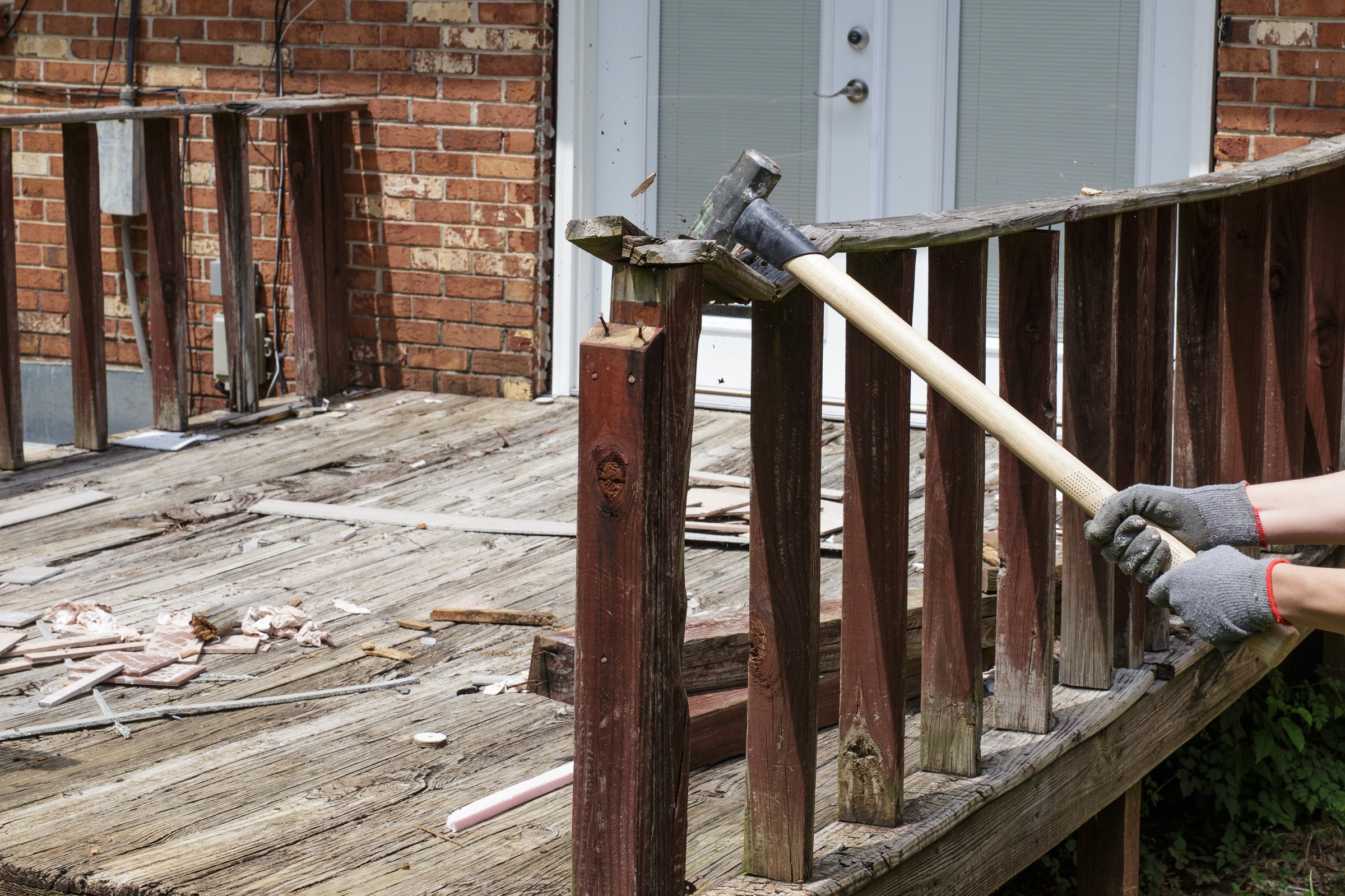 This weathered is in need of repair and upgrading.  Using a sledgehammer to remove the old rotten wood.