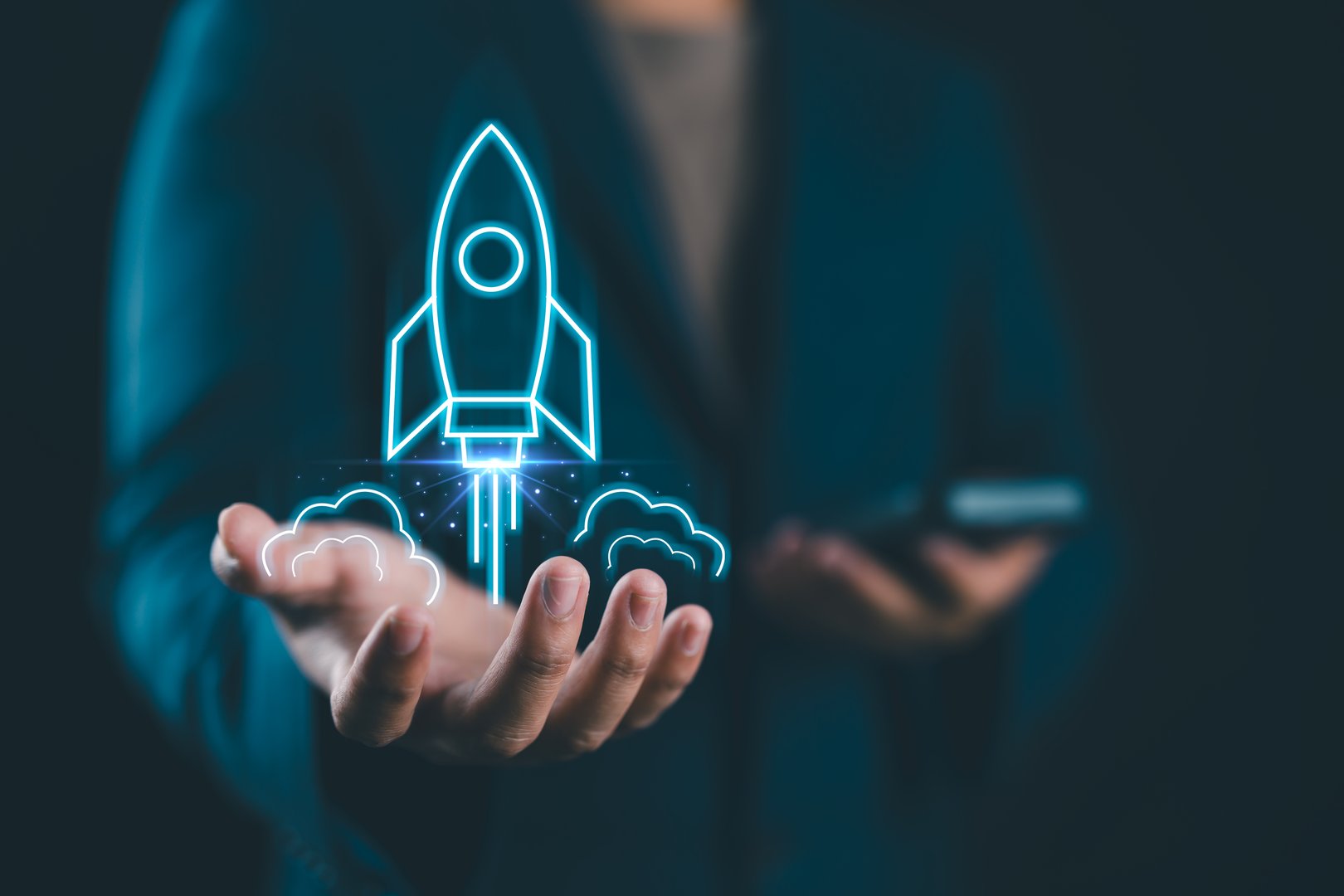 Businessman holding a holographic rocket launching above their hands, symbolizing innovation and startup success.