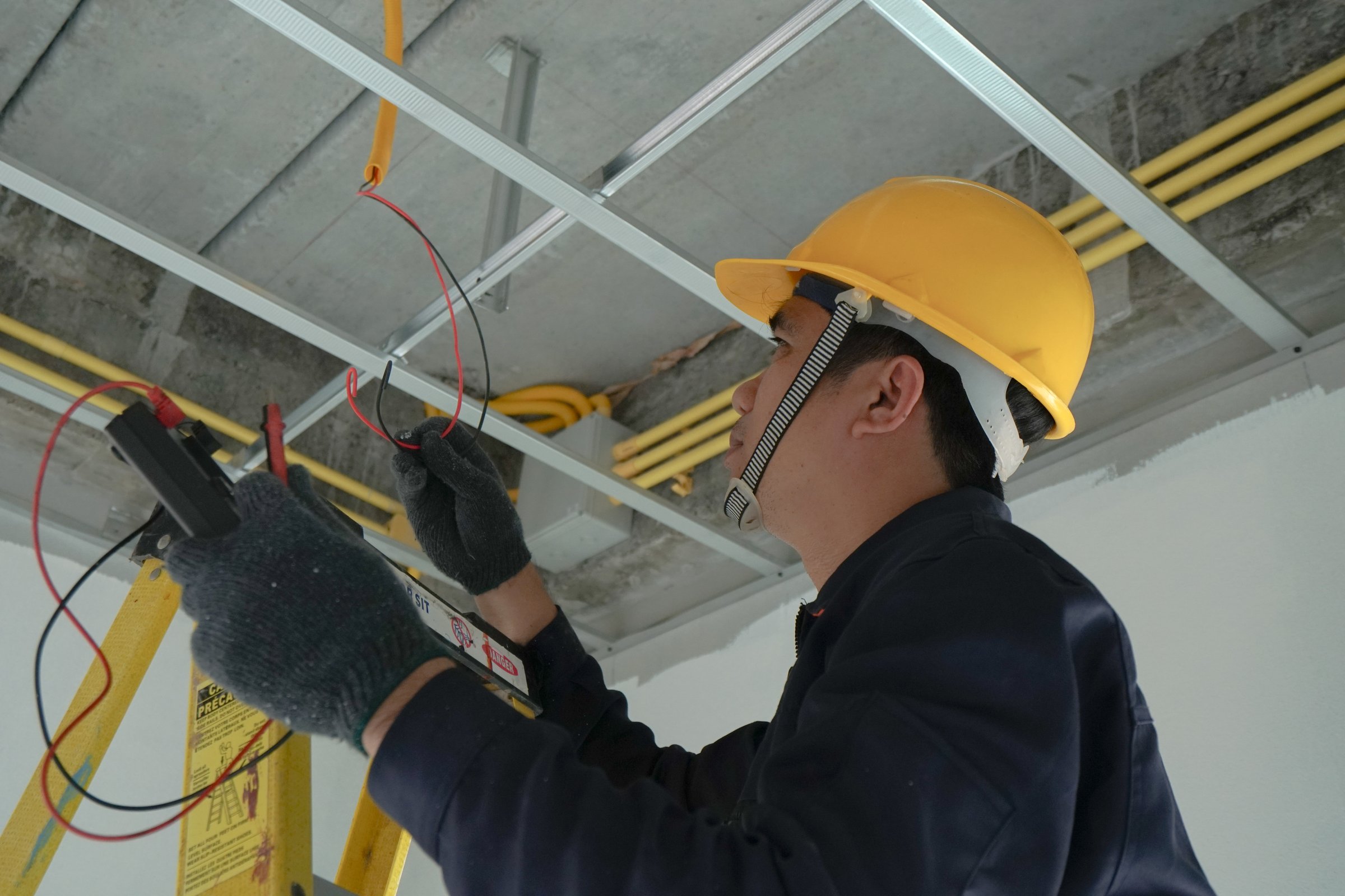 Electrician checking the current for the installation of electrical system in the house. Concept of electrical installation in the house and safety in construction.