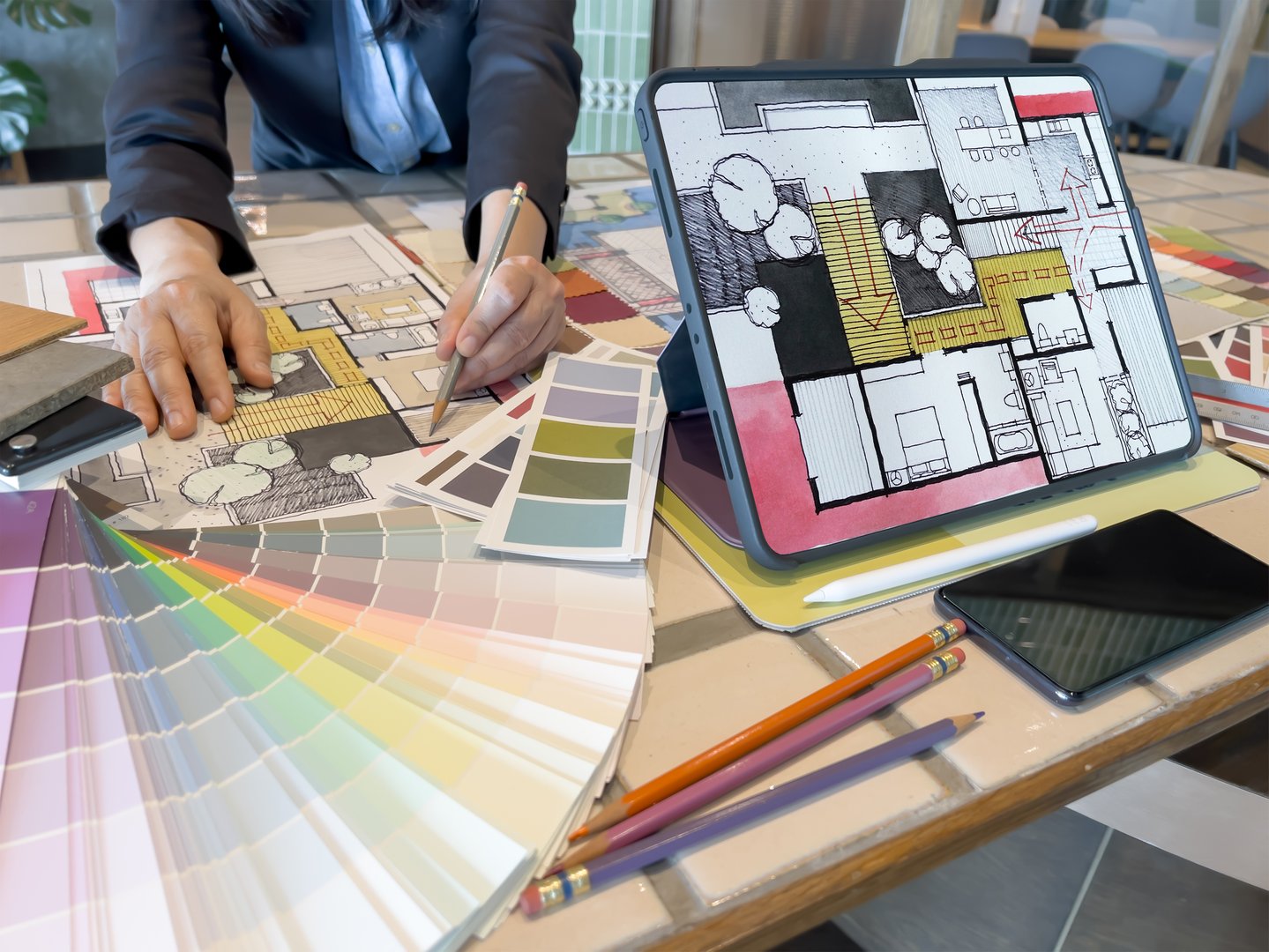 An Architect (Interior designer) working while selecting material sample with tablet. Home design with smart device &amp; modern technology concept.