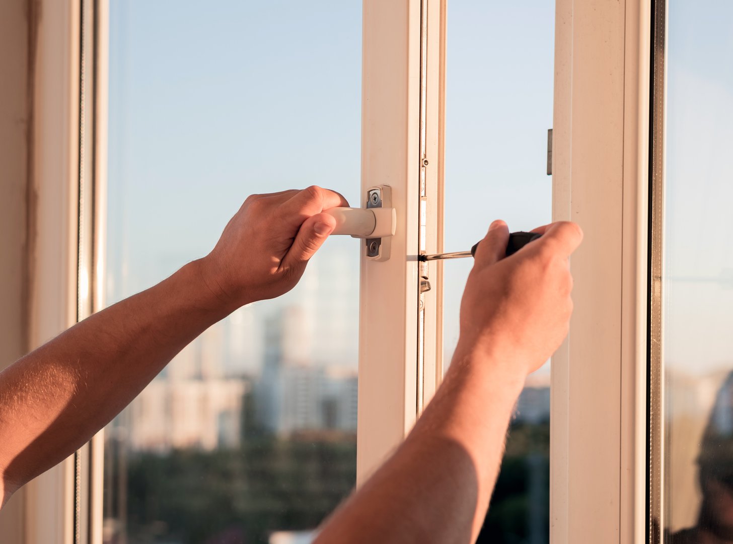 Handyman repairing the window on balcony.  adjusting plastic windows