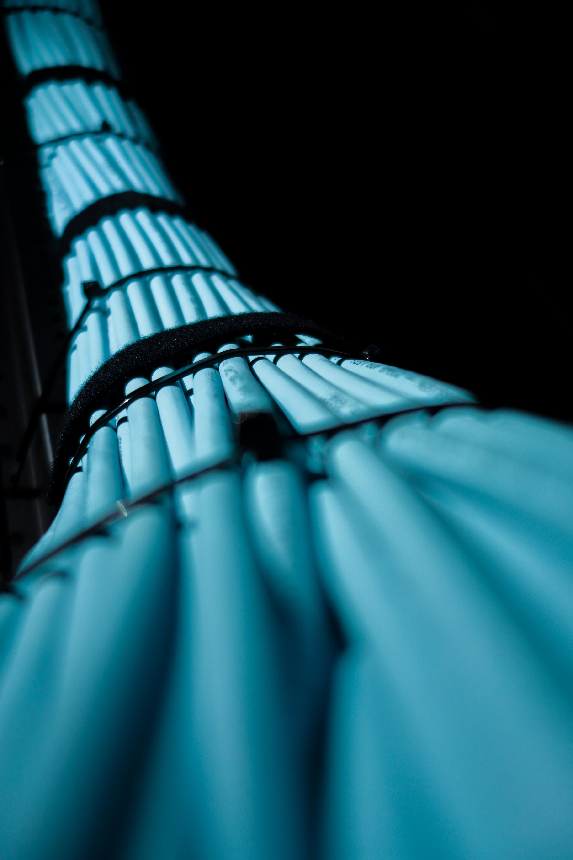 A striking close-up image of glowing blue cables against a dark background, showcasing the intricate design and technology of modern communication systems.