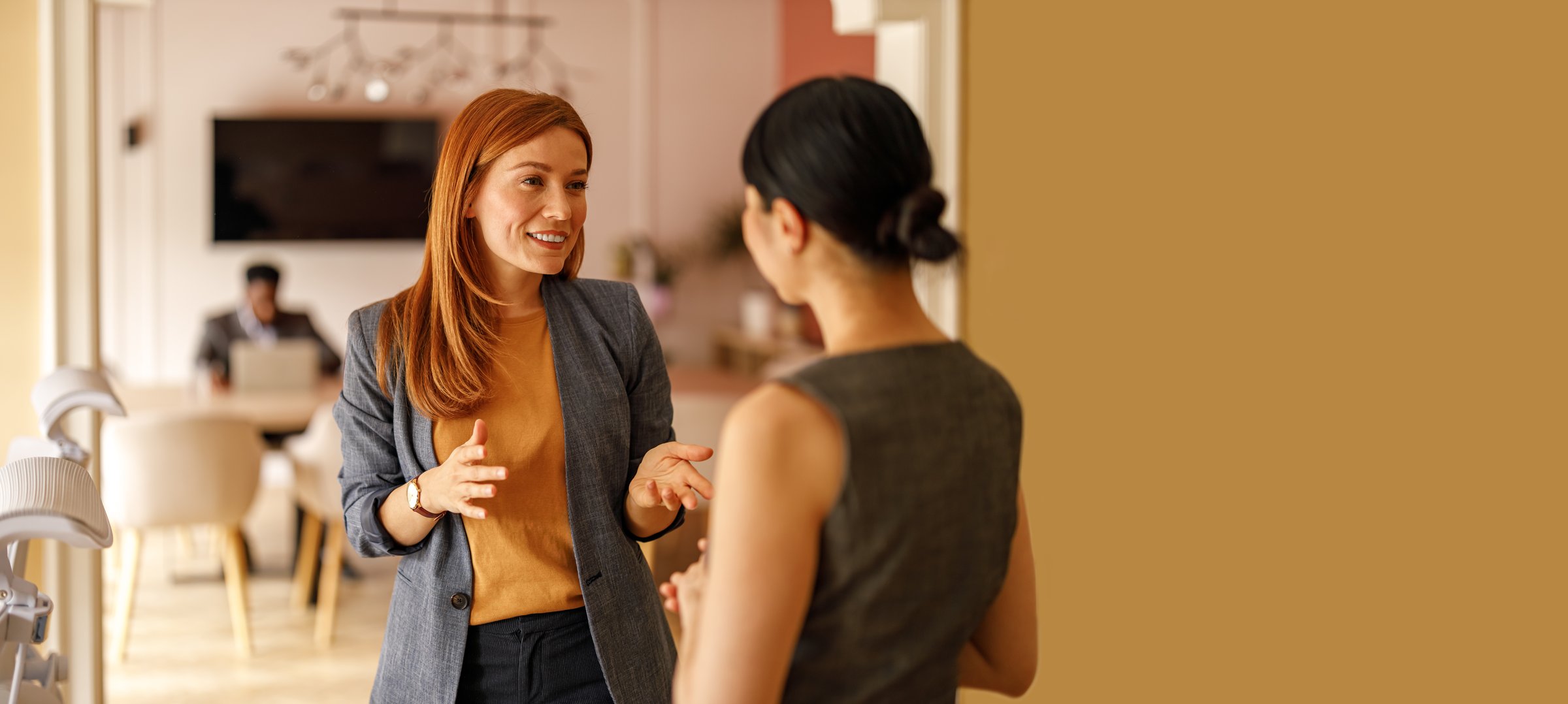 Confident female professional collaborating on business strategies with colleague in corporate office