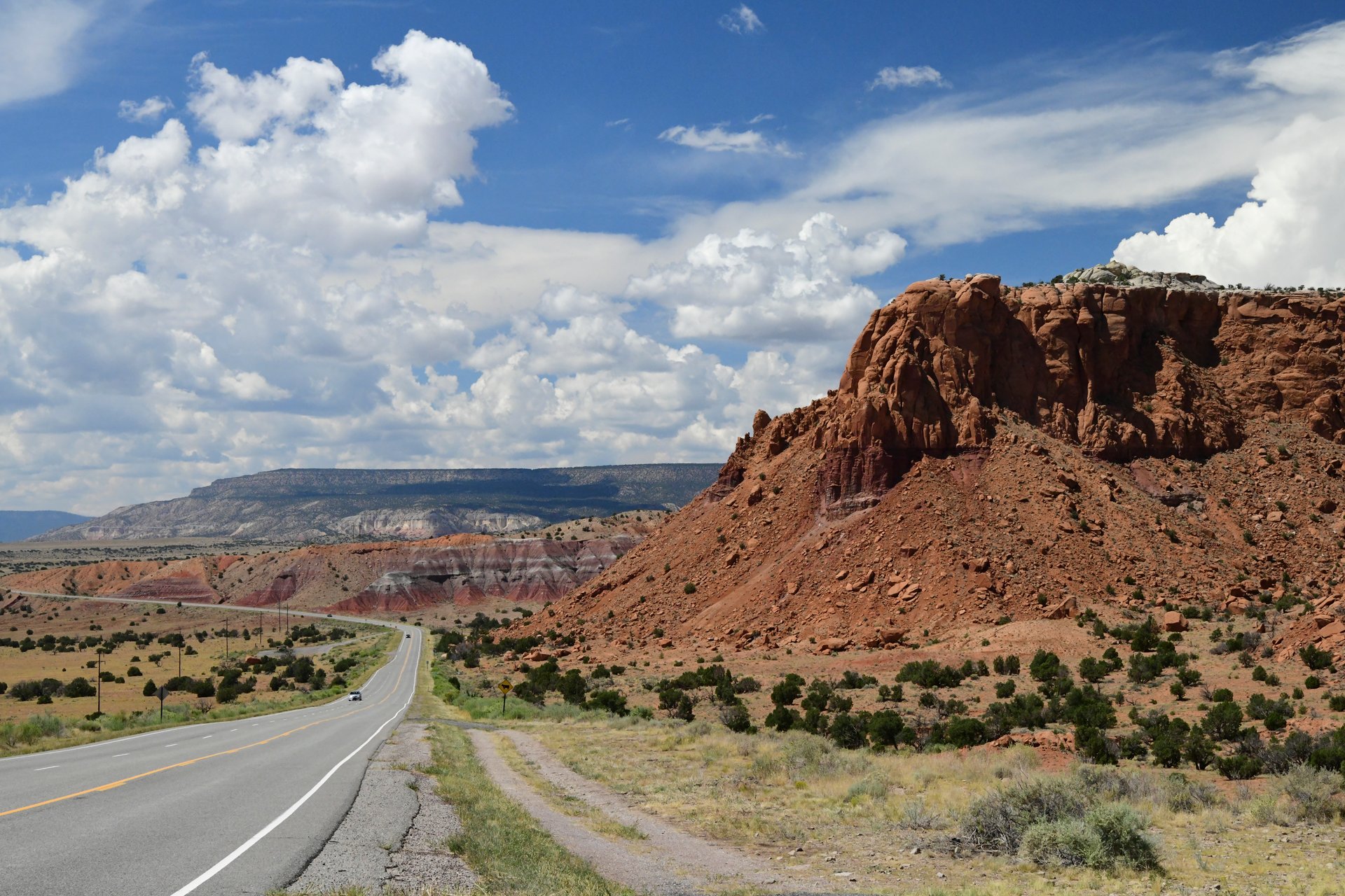 Abiquiu NM USA- August 26, 2025:  A lone traveller drives  Highway 84 - Outside of Abiquiu NM. The State Highway system is an essential link in the economy of the US.