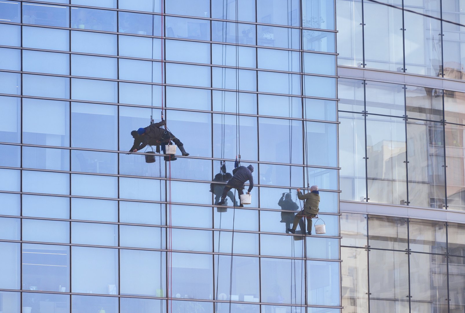Almaty, Kazakhstan - February 21, 2025: A group of people cleaning the glass facade of a building. Cleaning company