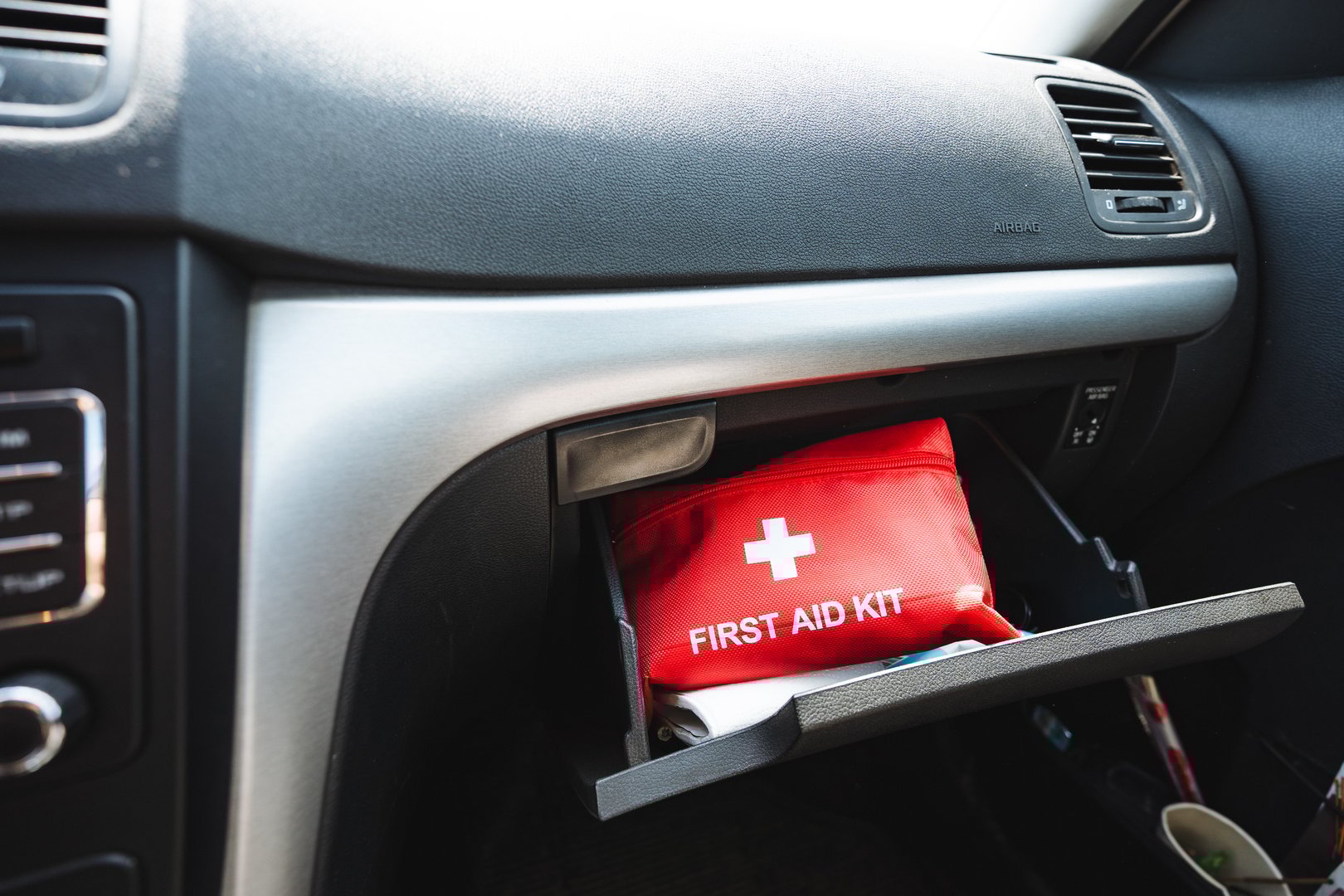 A first aid kit is put in the glove compartment of the car, a compact bag for medicines, a red box with pills. High quality photo