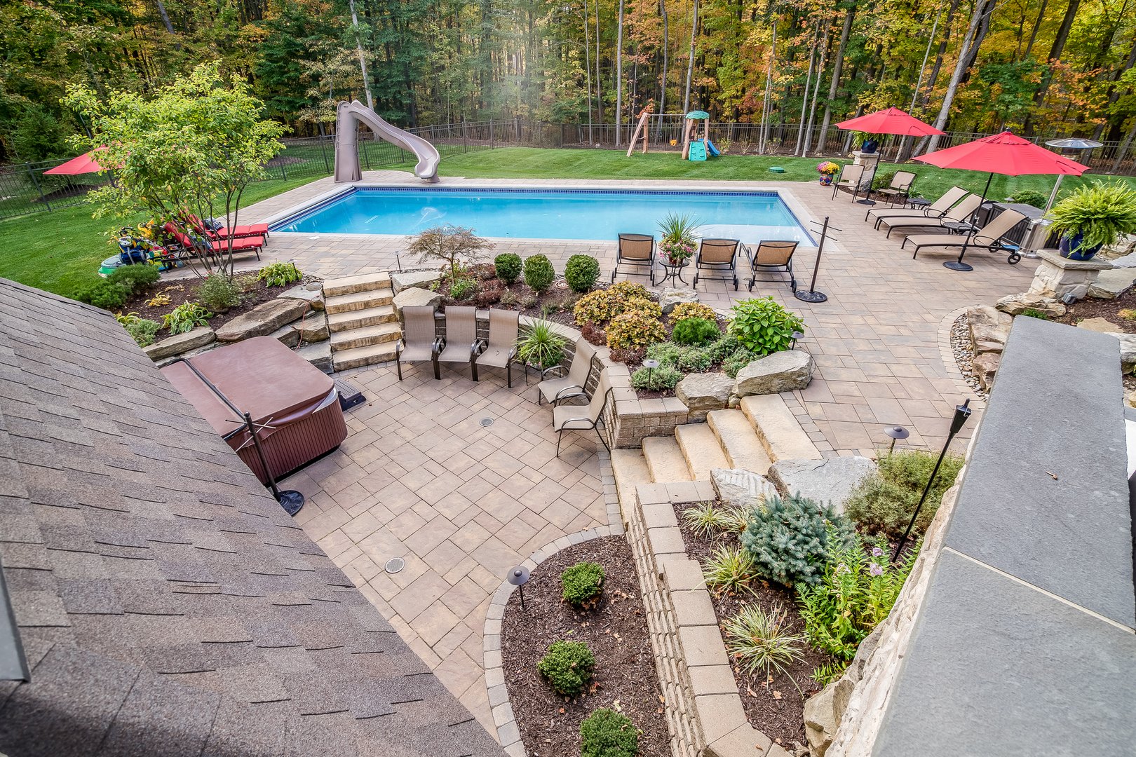Stone pavers, plants, hot tub, pool and nearby forest gives beautiful scenery