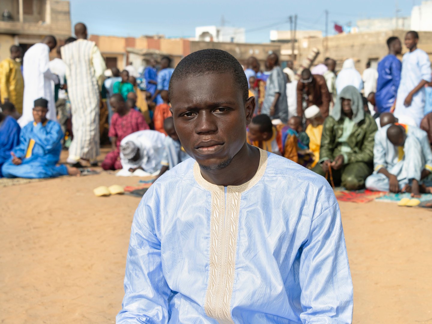Thiaroye, Dakar, Senegal, Africa – September 3, 2021: Street prayer, a Friday in Senegal. Unidentified young Muslim man praying in the street, celebration clothing