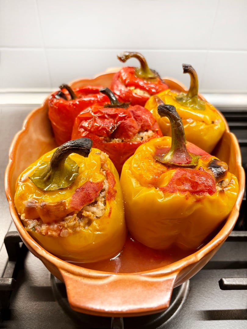 Stuffed peppers baked with minced meat, rice and tomato sauce in a tray. Directly above.