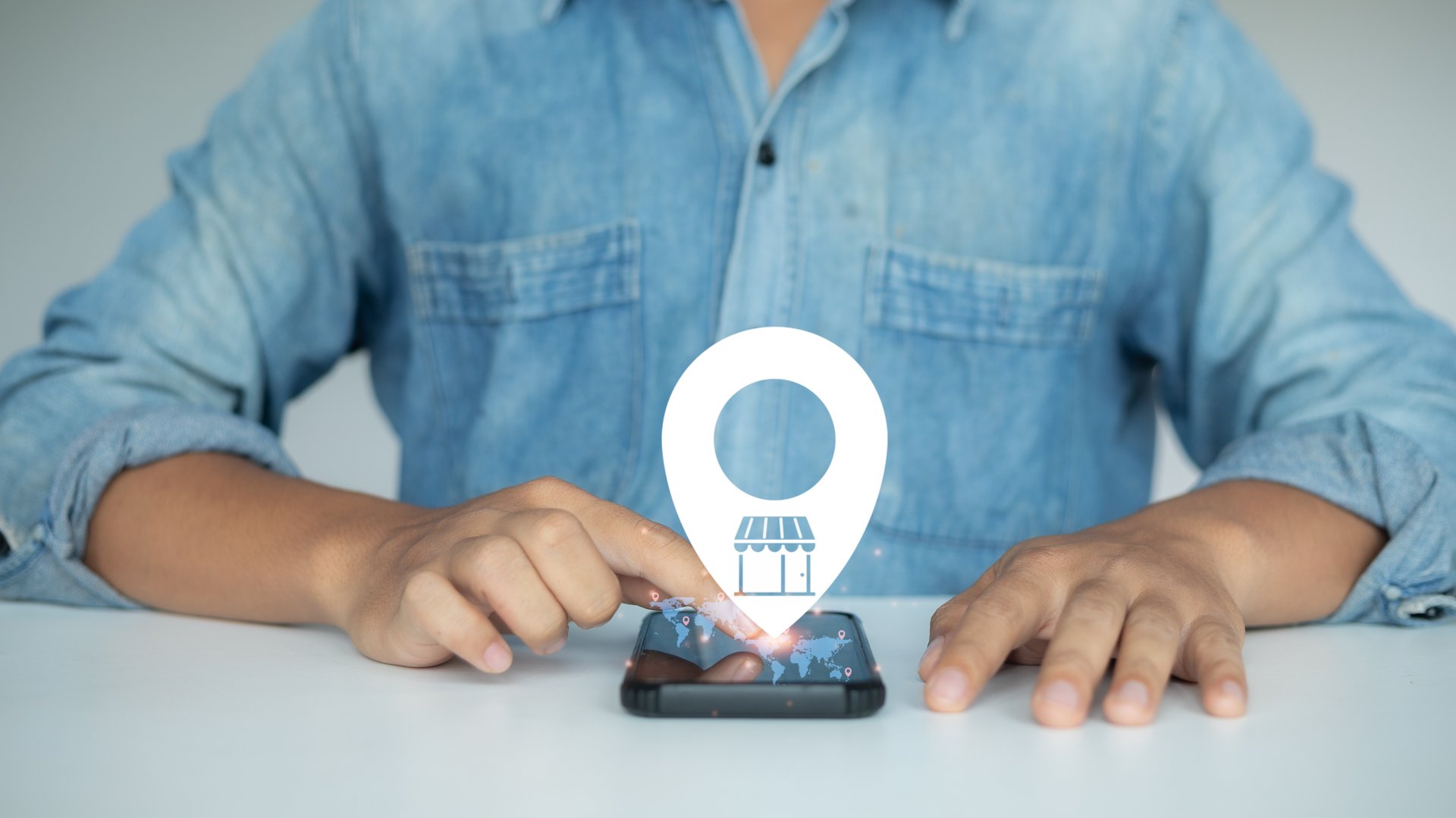 A man using a smartphone with a virtual map location icon and store symbol, representing online store location, local business search, and digital map navigation.