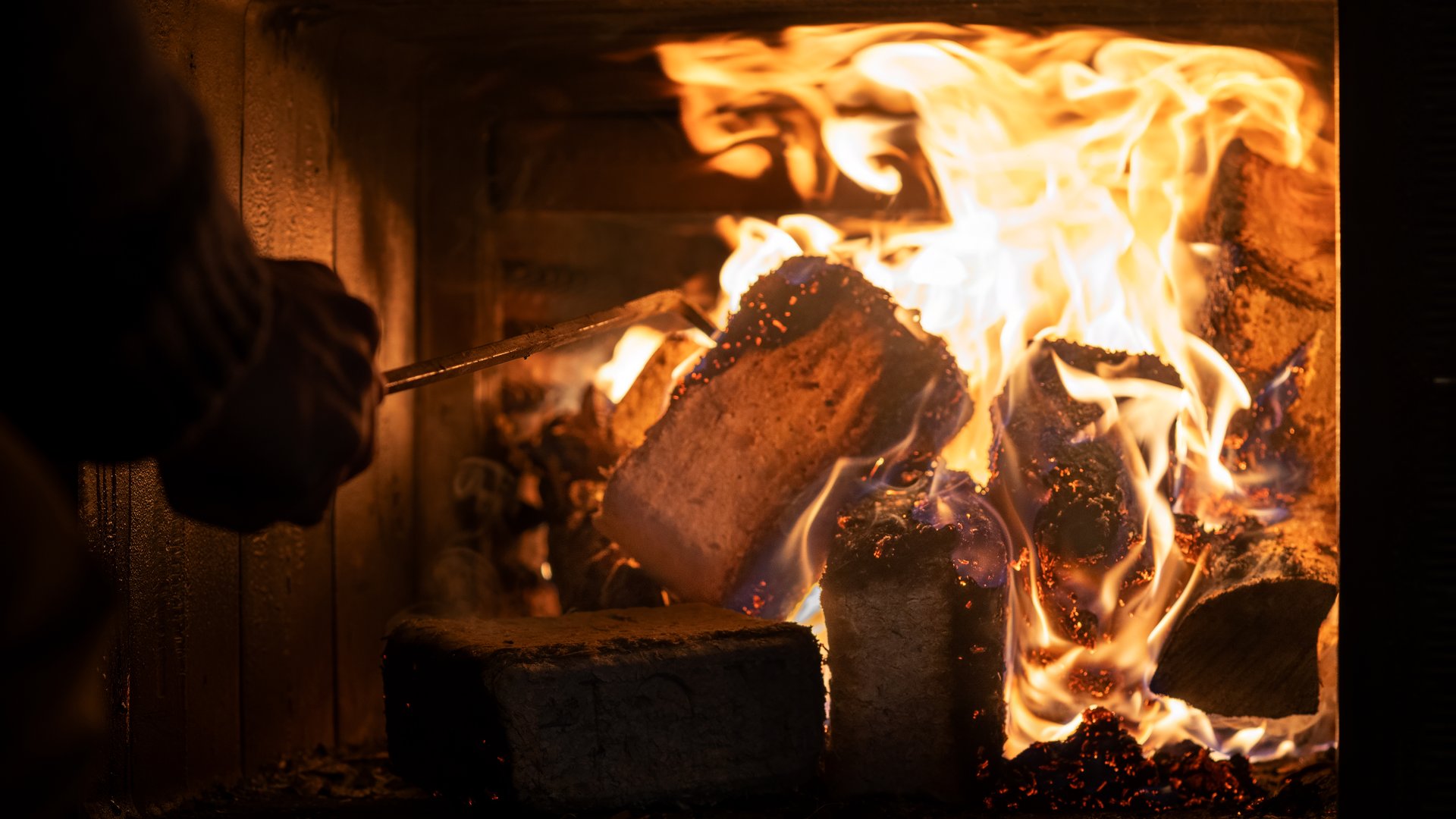 Eco-friendly compressed wood briquettes ignite a warm, inviting fire in a modern stove, showcasing sustainable heating and cozy ambiance for any home