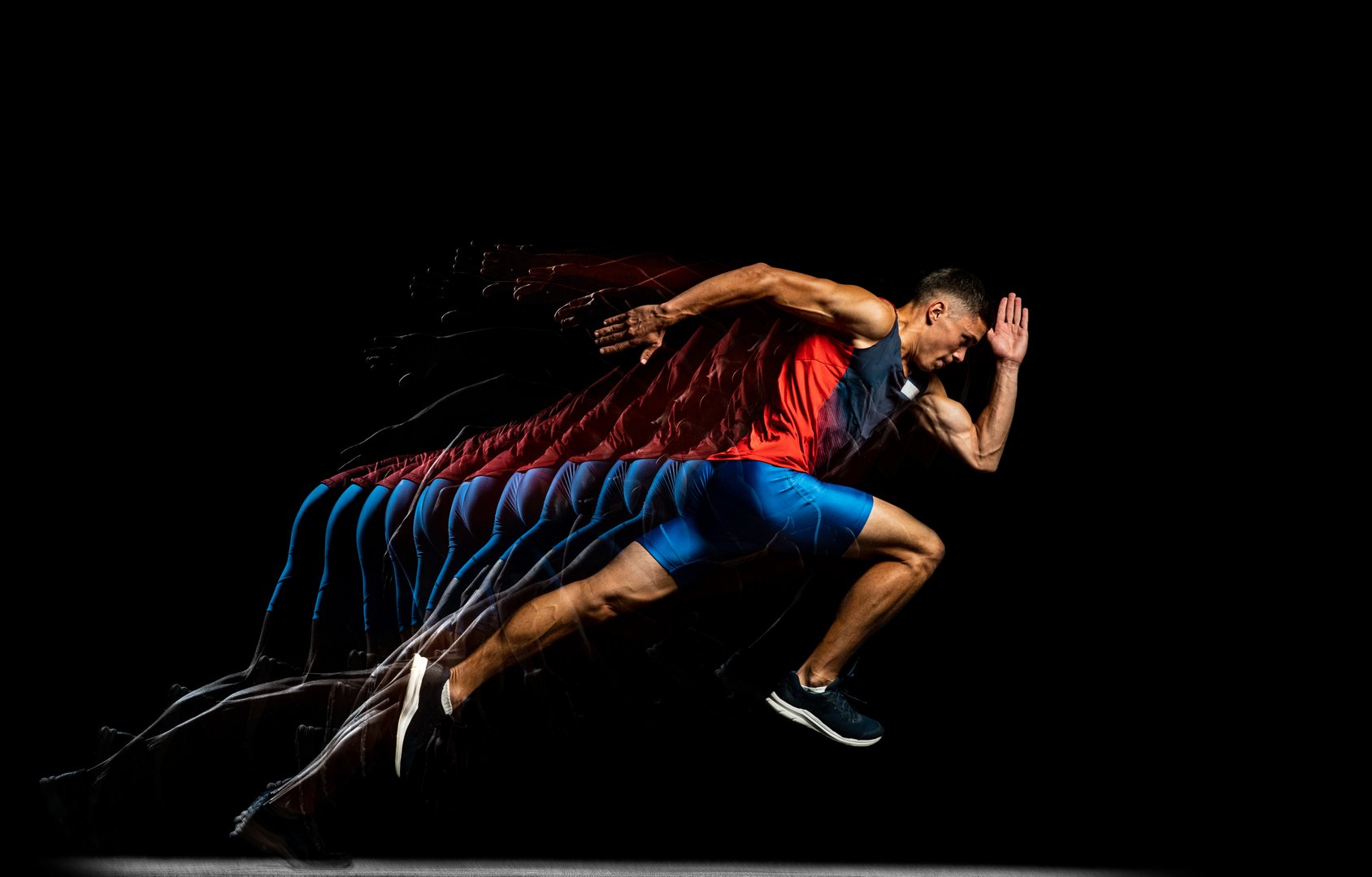 Developing strength. Young male athlete, professional runner in motion isolated over black background. Stroboscope effect. Concept of sport, action, energy, health, movement. Copy space for ad