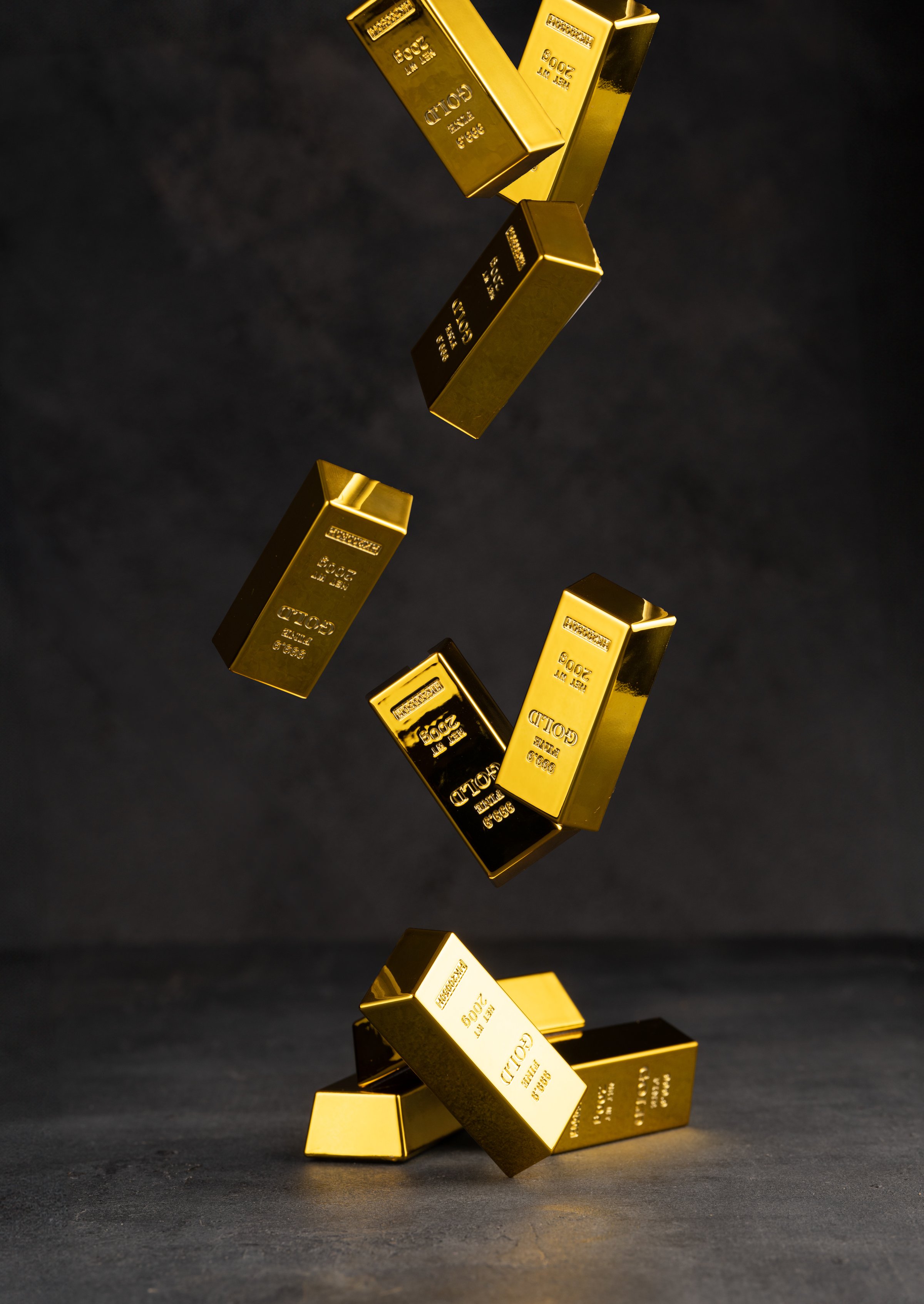 Golden bars on black background. Gold bars falling from above onto the black table