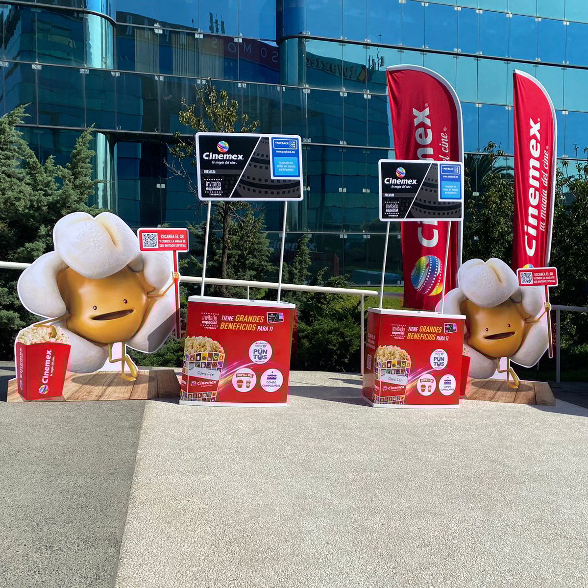 Cinemex popcorn character cutouts with promotional displays and banners outside a building.