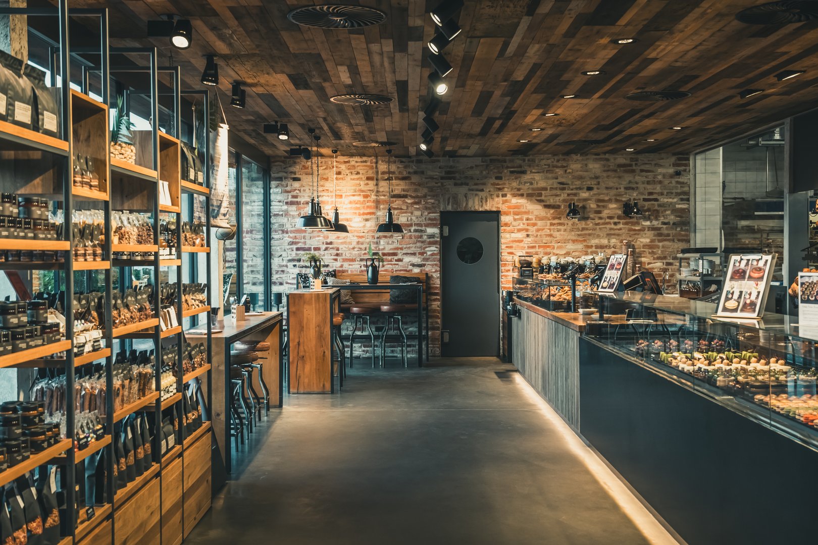 View of a modern bakery with shop and cafe, industrial style with brick wall, wood and black steel