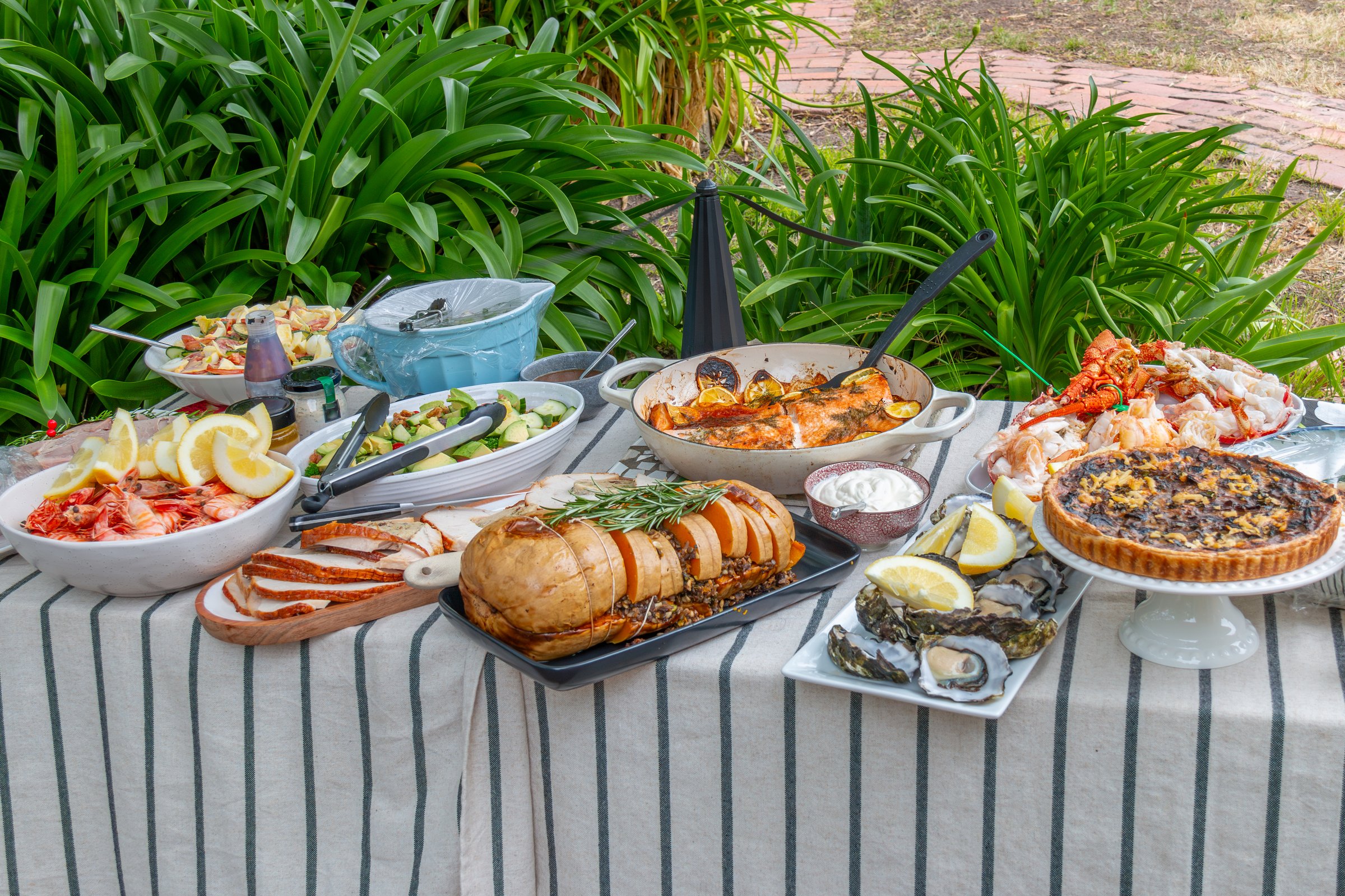 decadent luxury lunch buffet on outdoor table with fish, vegetables and salad