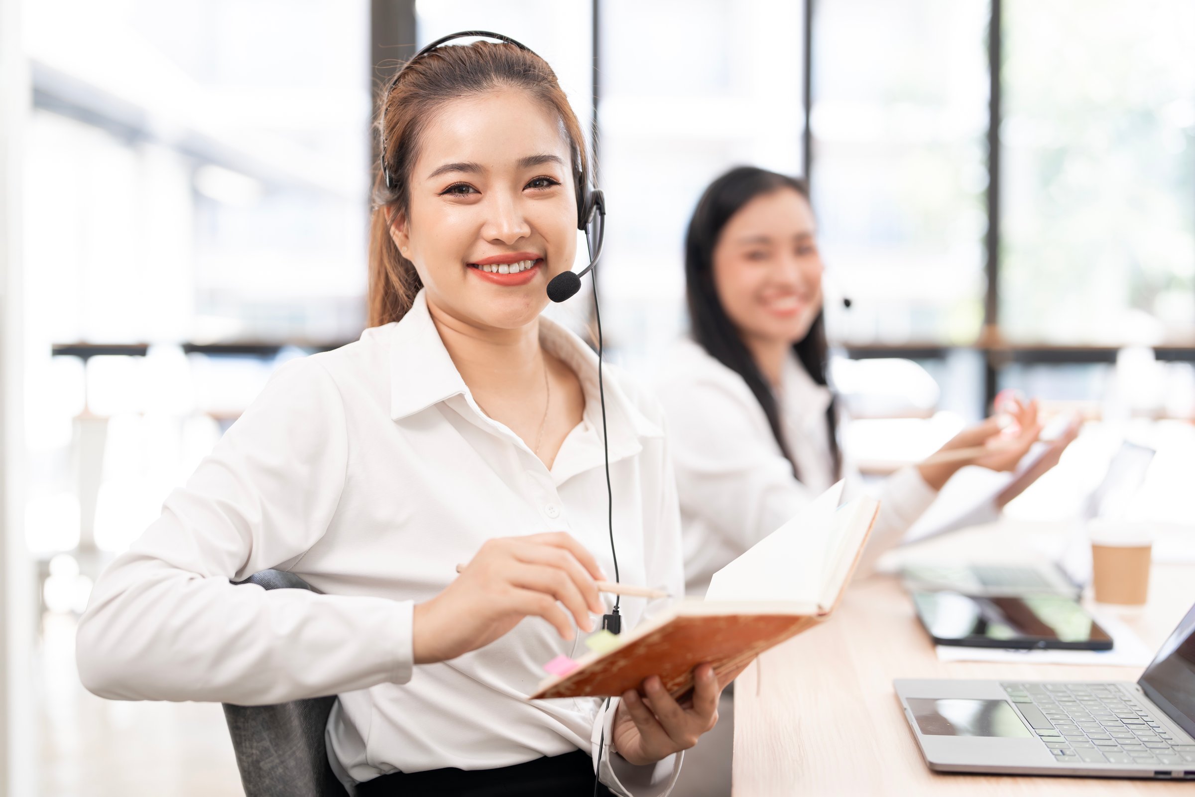 Beautiful asian businesswoman in call center consulting, speaking or talking at customer services.