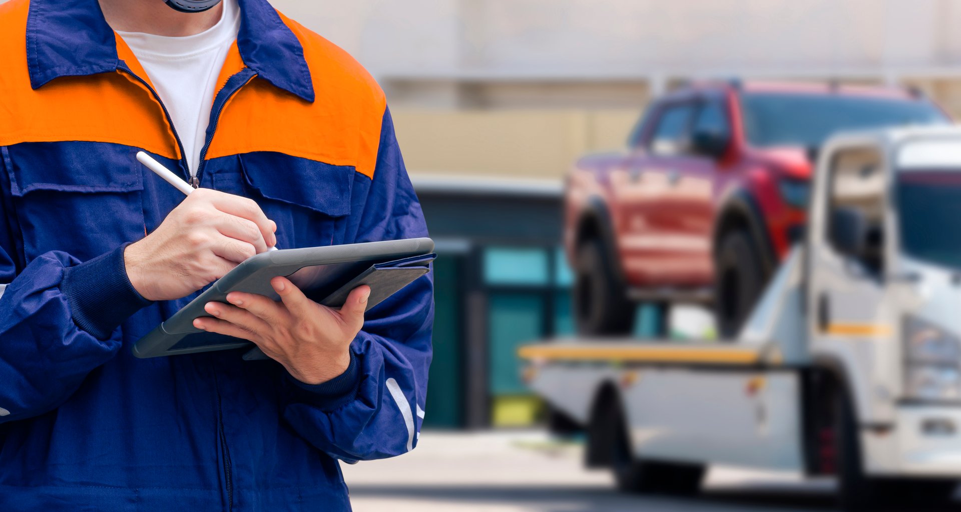 Close up of insurance officer using electronic pen to recording data of broken pickup car on tablet while prepare for transporting to garage after accident on the road