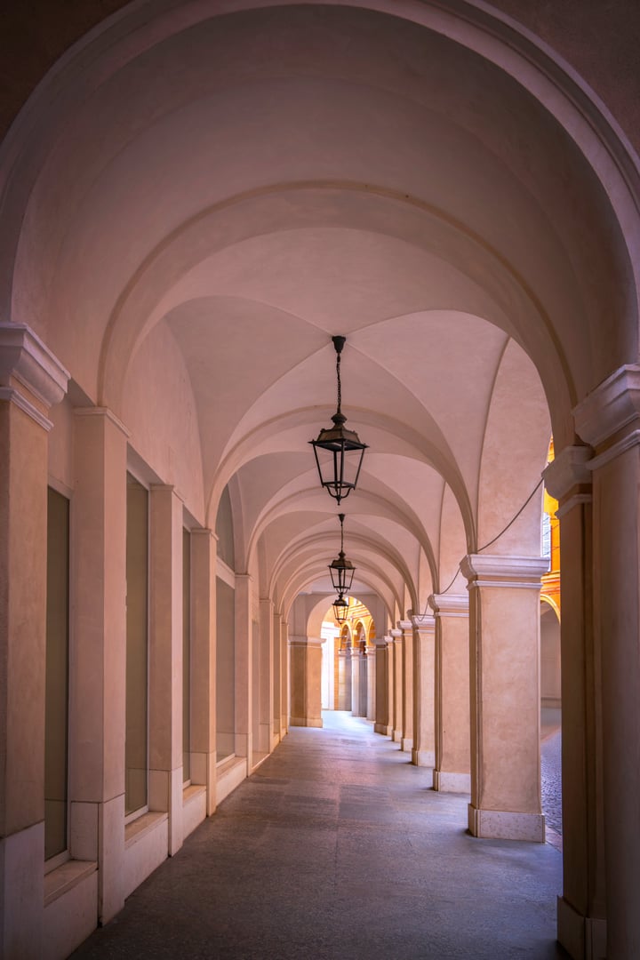 Abstract geometry of corridors (porticos) in Modena's historic center near Great Square (Piazza Grande) with arcades and elegant columns of Renaissance charm in Emilia-Romagna, Italy