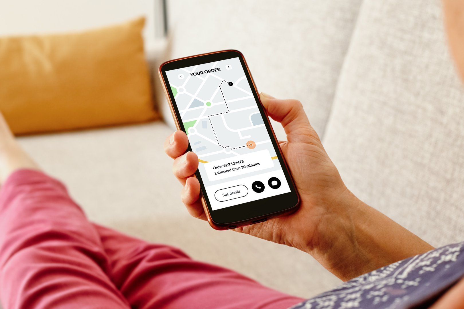 Woman on the sofa checking an online order status with delivery tracking app on smartphone.