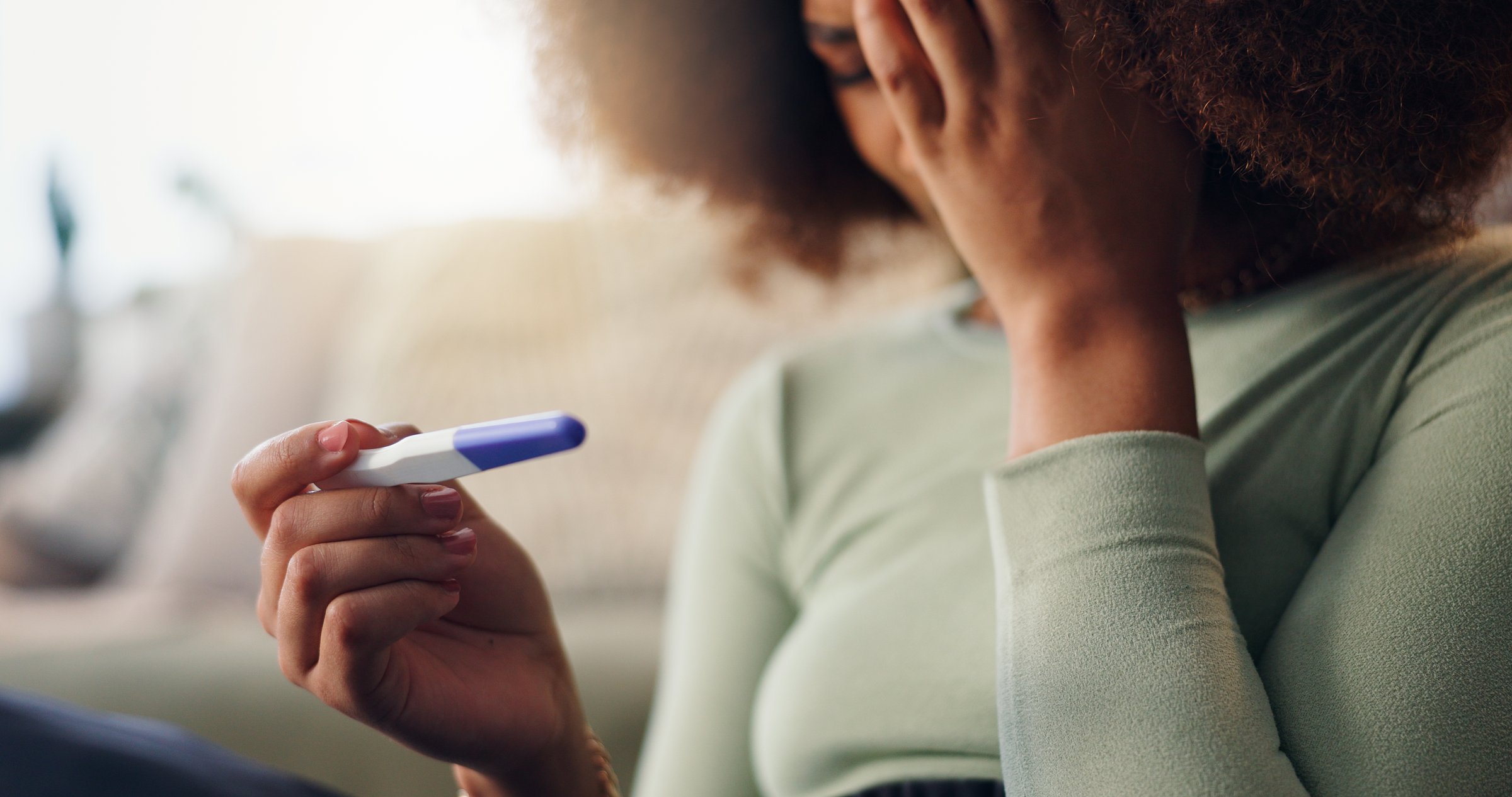 Anxiety, pregnancy test and result with woman in home living room for detection or screening. Fertility, ovulation and waiting with fail or negative emotion of pregnant person on floor of apartment