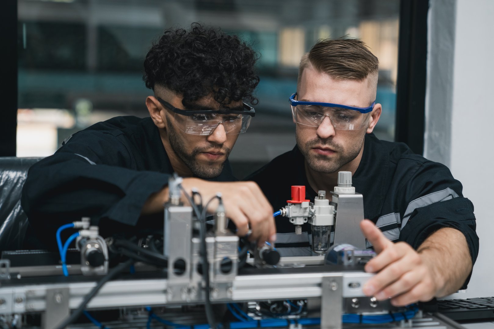 Student engineer Assembling Robotic Arm with computer in Technology Workshop. Service Engineer Holding Robot Controller and Checking Robotic Arm Welding Hardware.