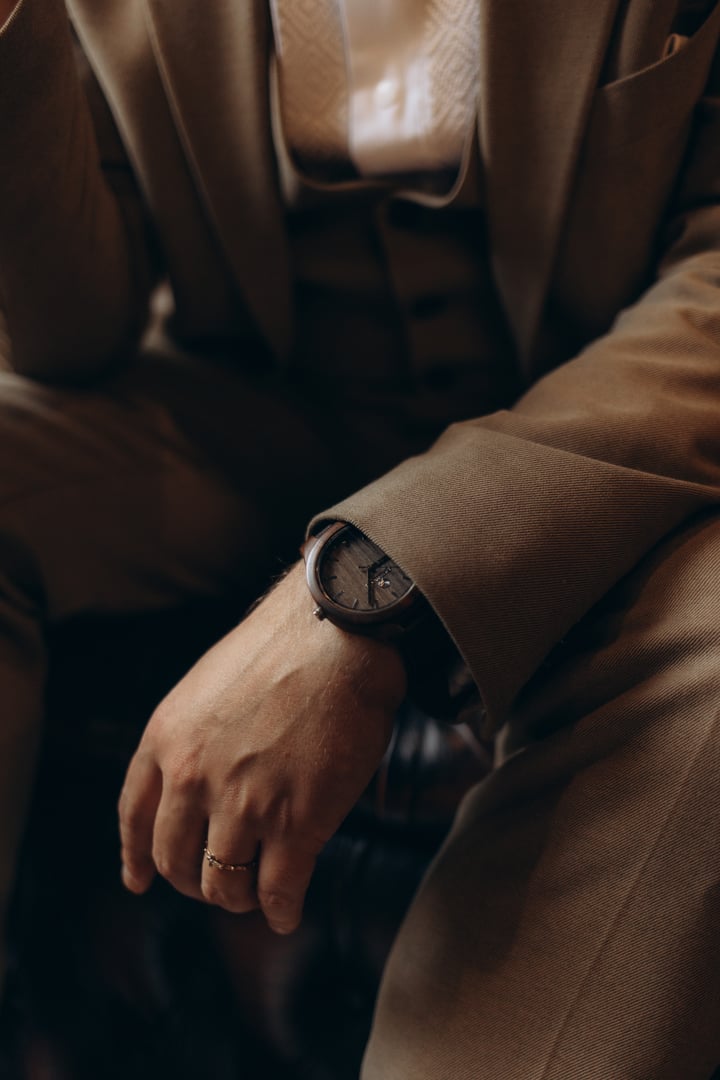 The man in the white shirt in the window wears watches.