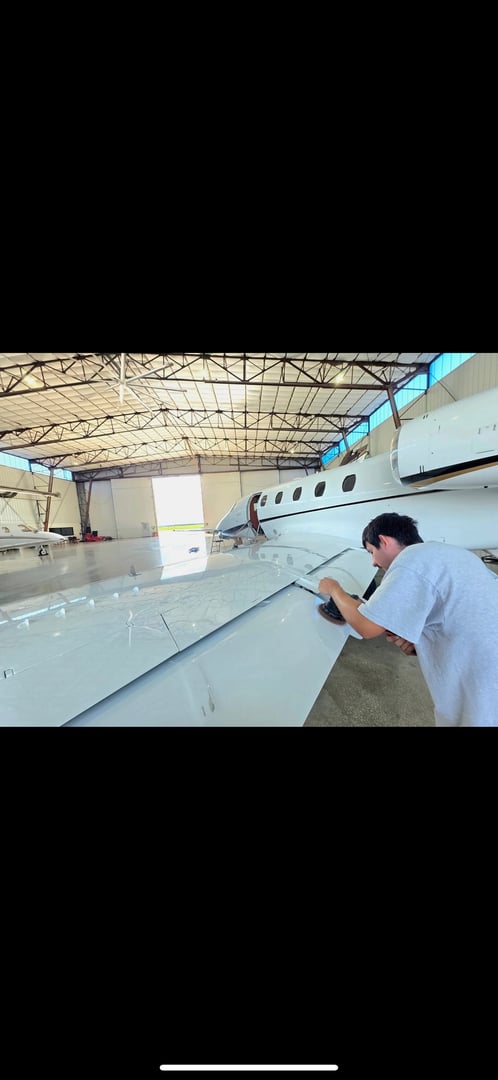 VIP Business jet with open door on the tarmac of an airport showcasing professional aircraft detailing services