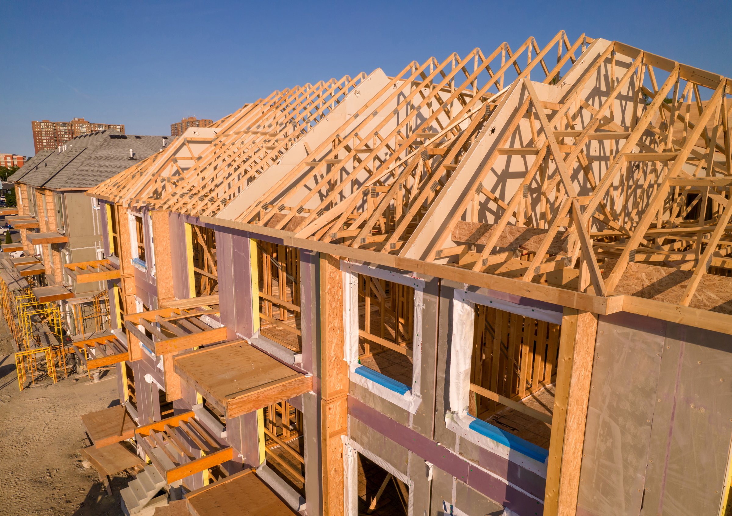 House construction and its wooden roof. Wooden housing. Timber frame house in North American downtown real estate.