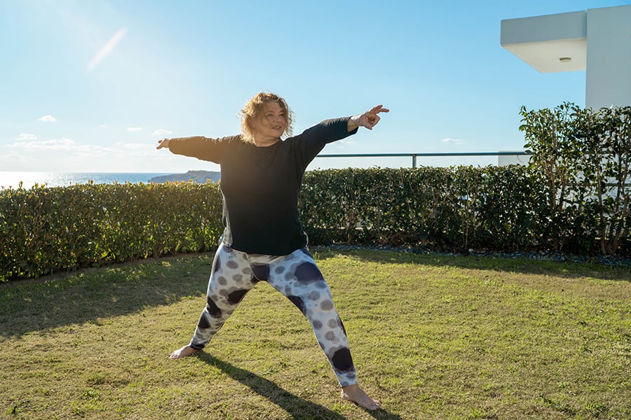 Portrait Of Beautiful Young Female Making Yoga Practice In Light Studio, Happy Smiling Millennial Woman Sitting On Fitness Mat And Doing Pilates Exercises, Enjoying Healthy Lifestyle, Copy Space