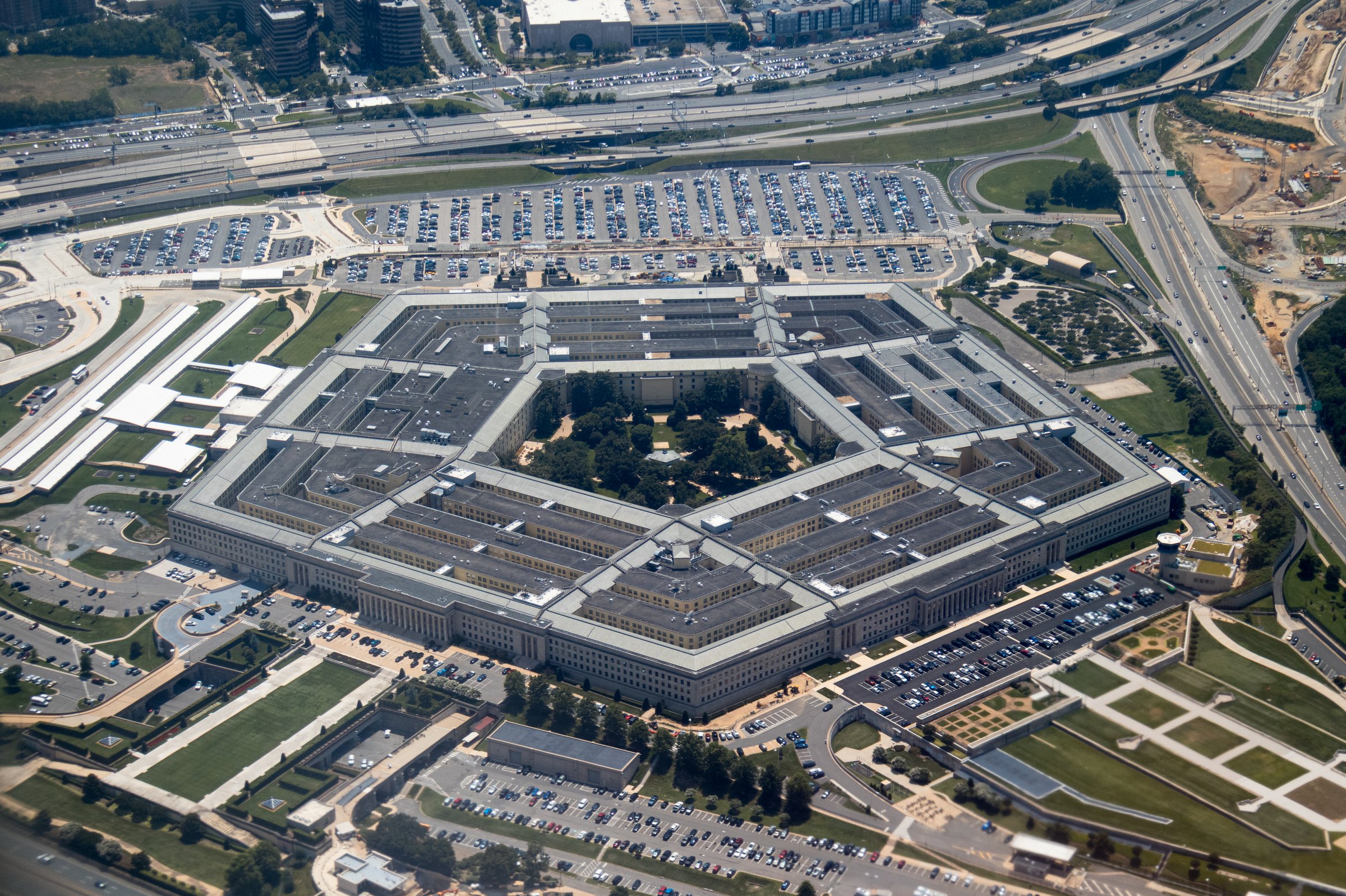 Aerial view of the Pentagon complex with surrounding roads, parking and greenery. g.