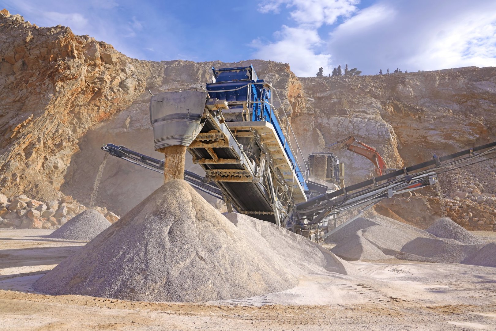 Modern stone crushing machine and conveyor belts at an open pit mining operation, showcasing industrial quarry equipment for processing crushed stone and gravel materials