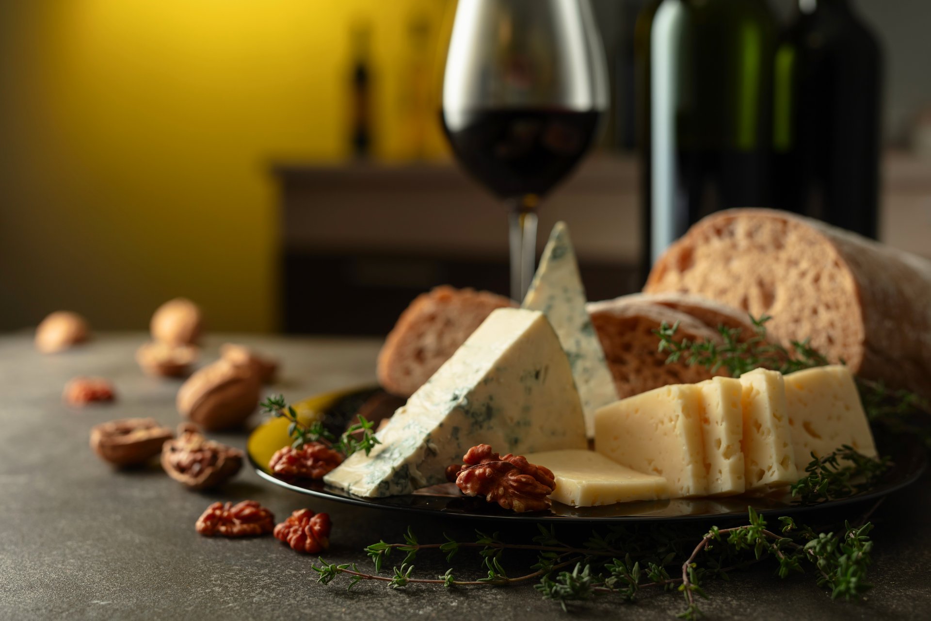 Cheese, bread, red wine, and walnuts on a kitchen table. Traditional Mediterranean snacks.