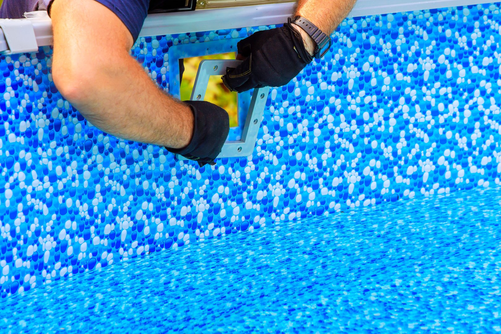 Craftsman carefully installs new pool filtration system over liner at home backyard