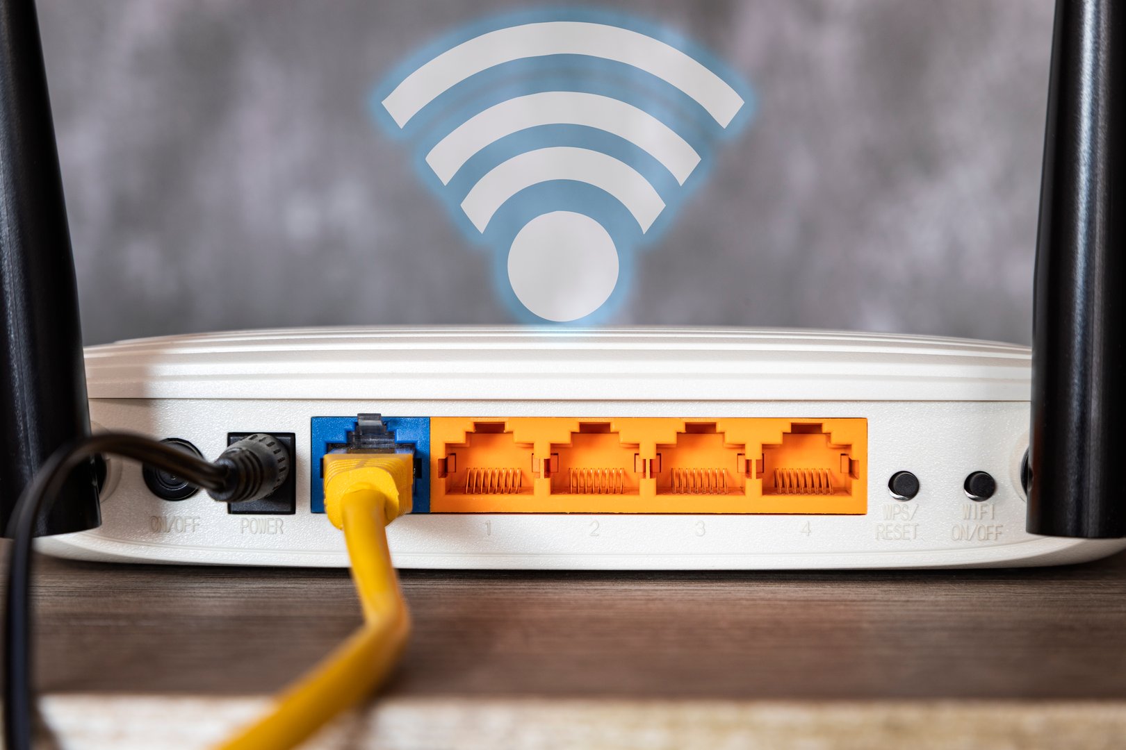 Wifi router is connected to a yellow cable. The cable is plugged into the router and is likely used to connect to the internet