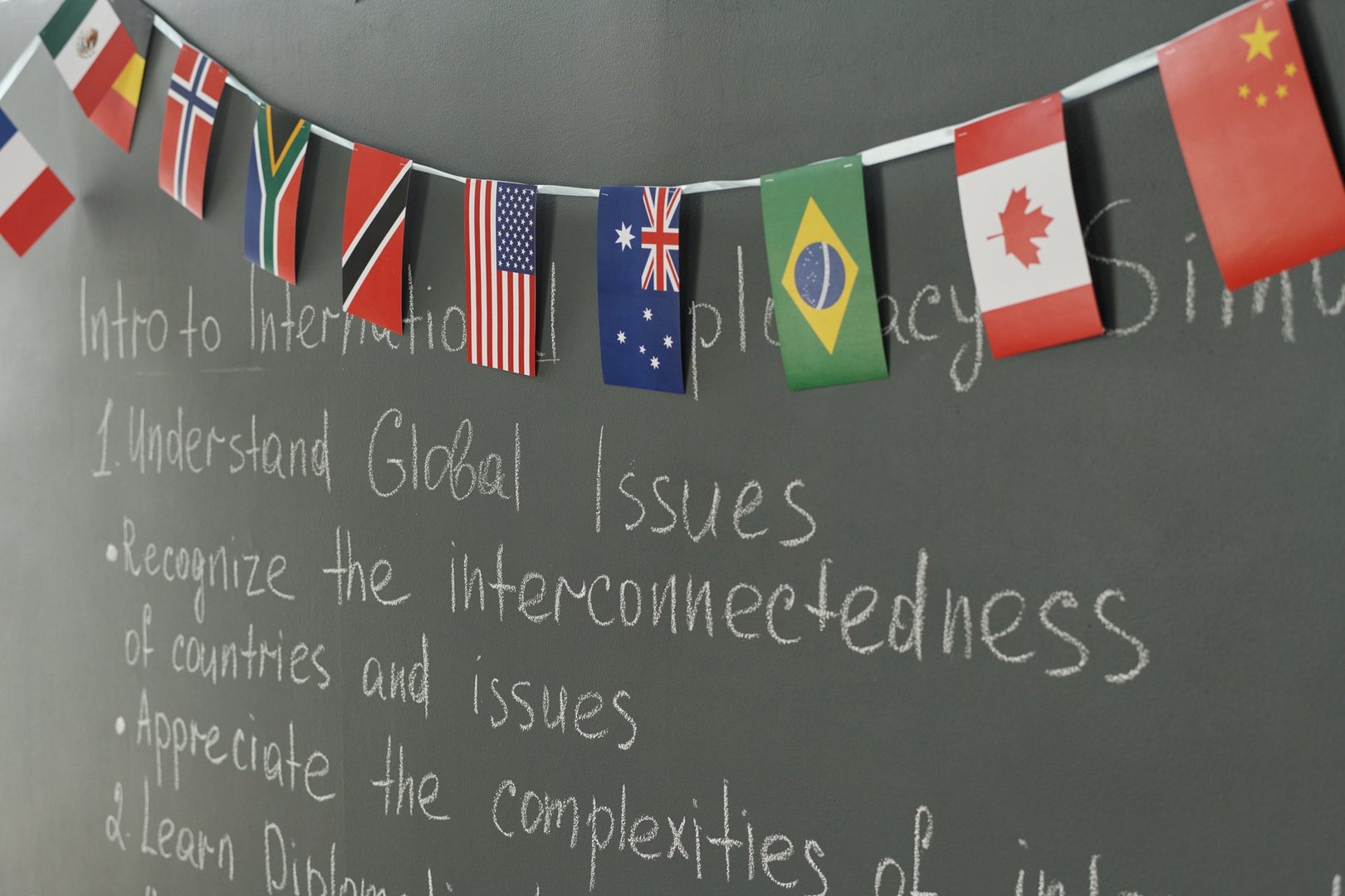 Blackboard with flags of different countries in school classroom, copy space