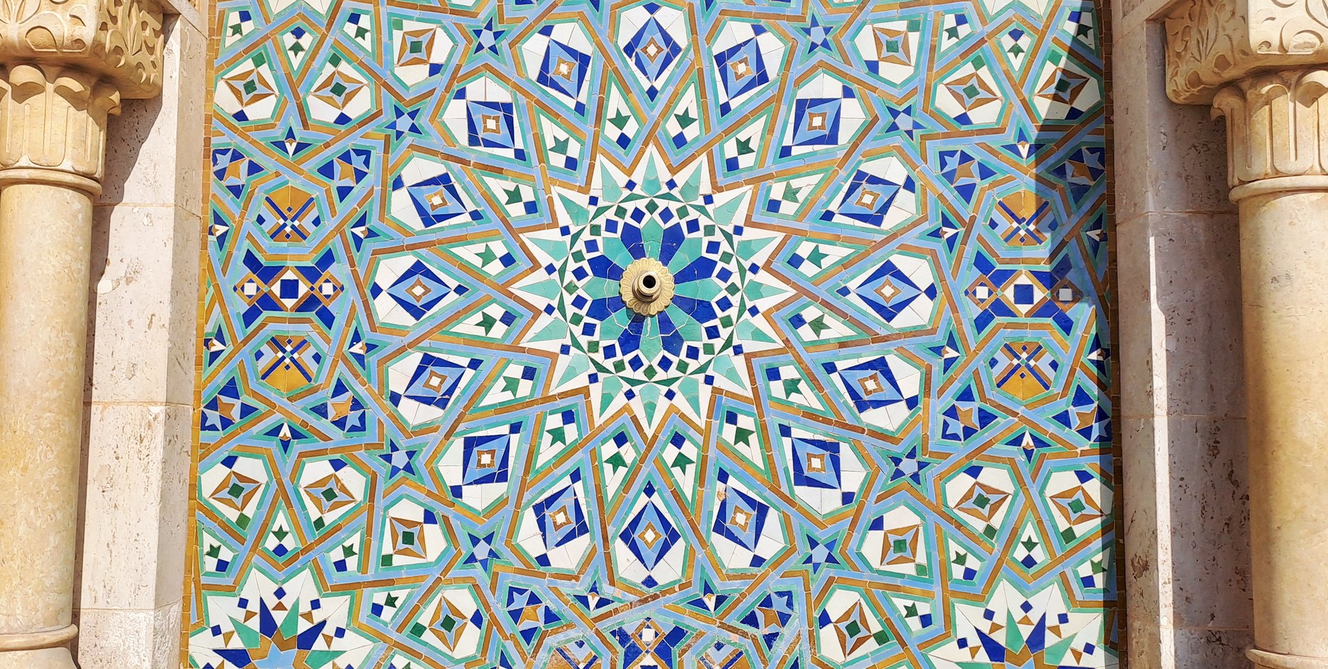 Intricate moroccan zellige tile mosaic adorns a fountain, showcasing vibrant colors and complex geometric star patterns